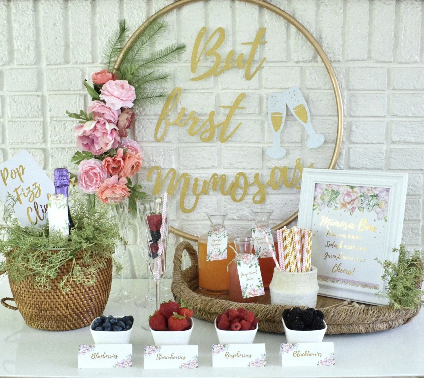 A bar with liquor bottles, wine glasses hanging upside down, and bartending supplies on a marble countertop in a restaurant or bar setting.