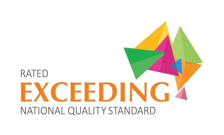 A colorful abstract logo with overlapping triangles in green, pink, orange, blue, and yellow. The text reads: "Rated Exceeding National Quality Standard" with "Exceeding" in large orange letters.