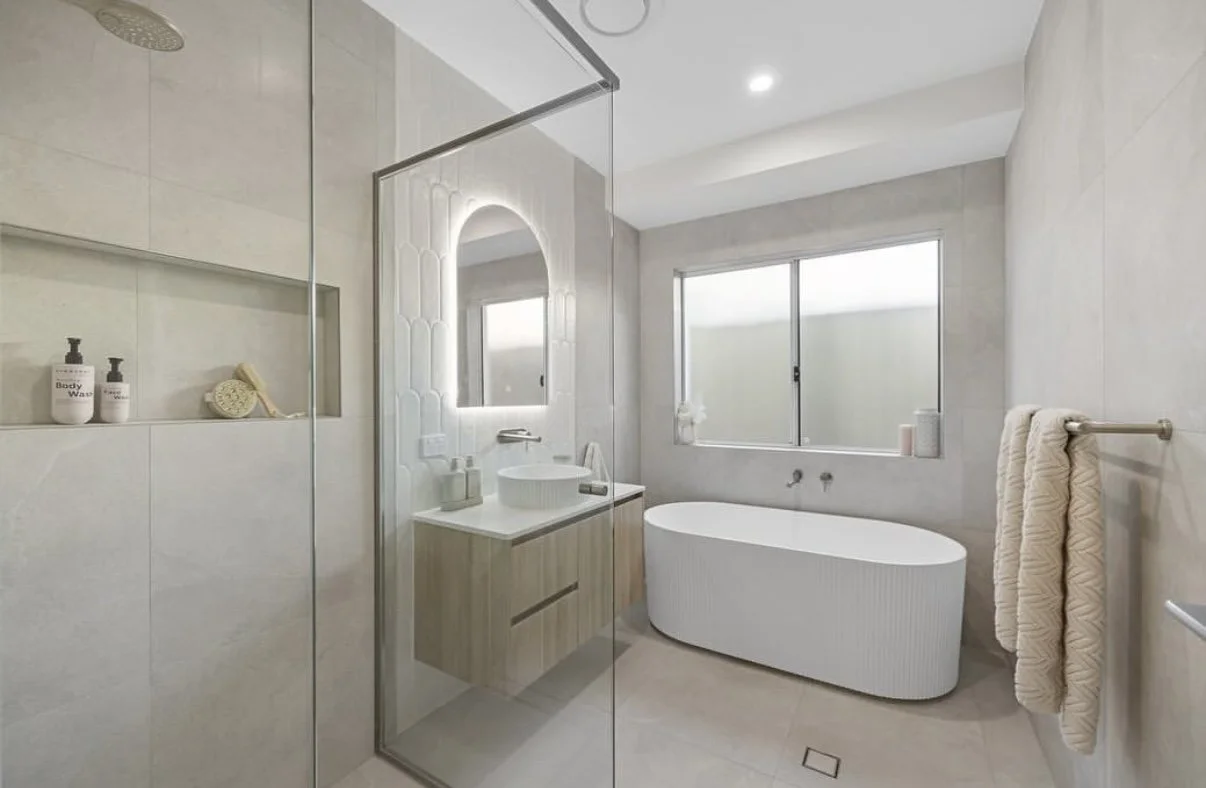 Modern bathroom with walk-in shower, freestanding bathtub, vanity with mirror, and large window.