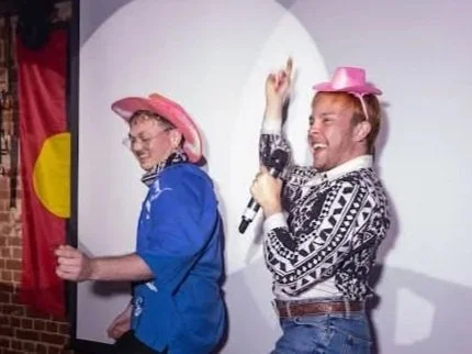 Two young men, Seth & Denver, teaching line dancing in pink cowboy hats