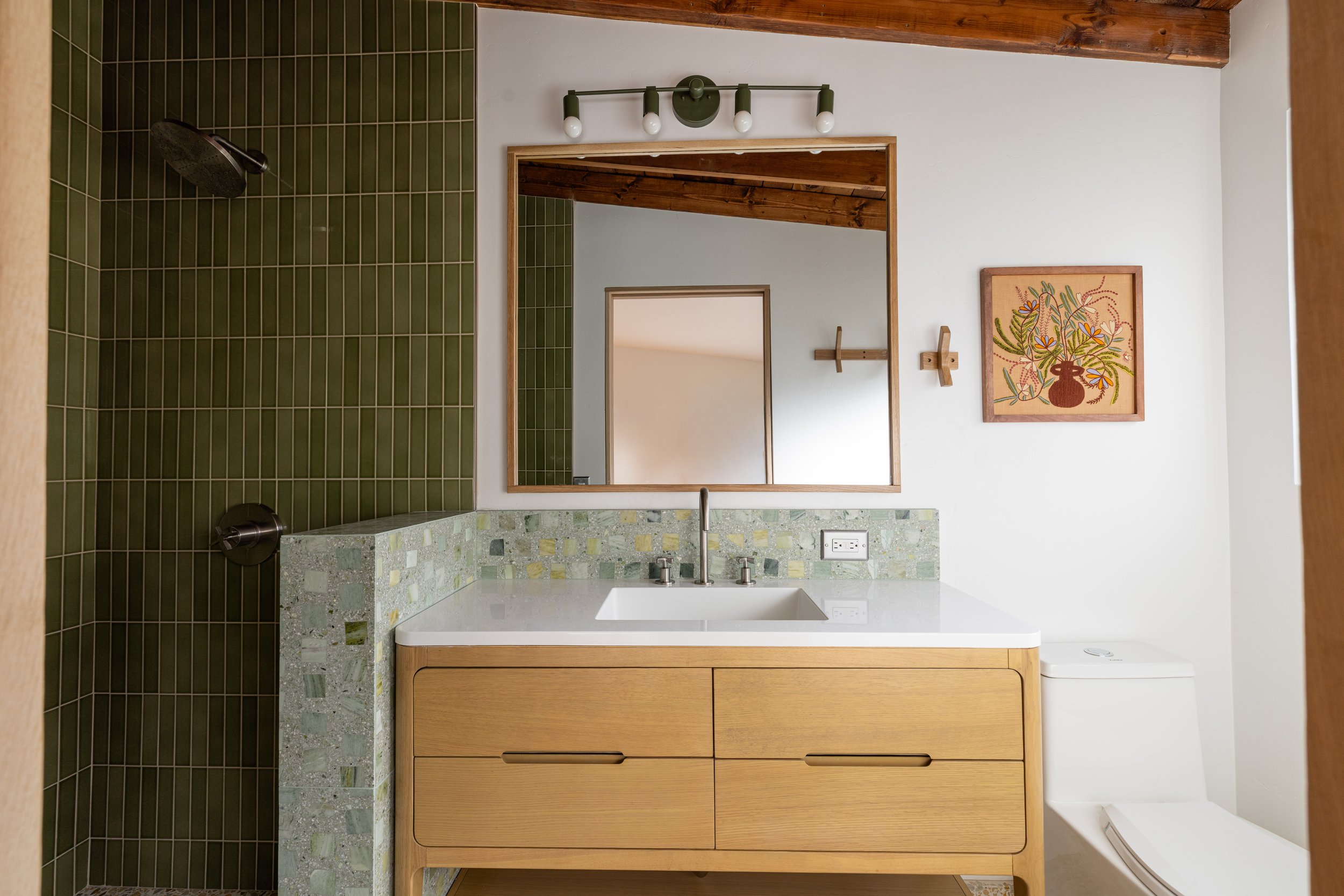 Remodeled bathroom, midcentury modern feel. Zia Tile shower and Concrete Collaborative floor and backsplash. Green tones and white oak accents. Designed by Geis Architecture