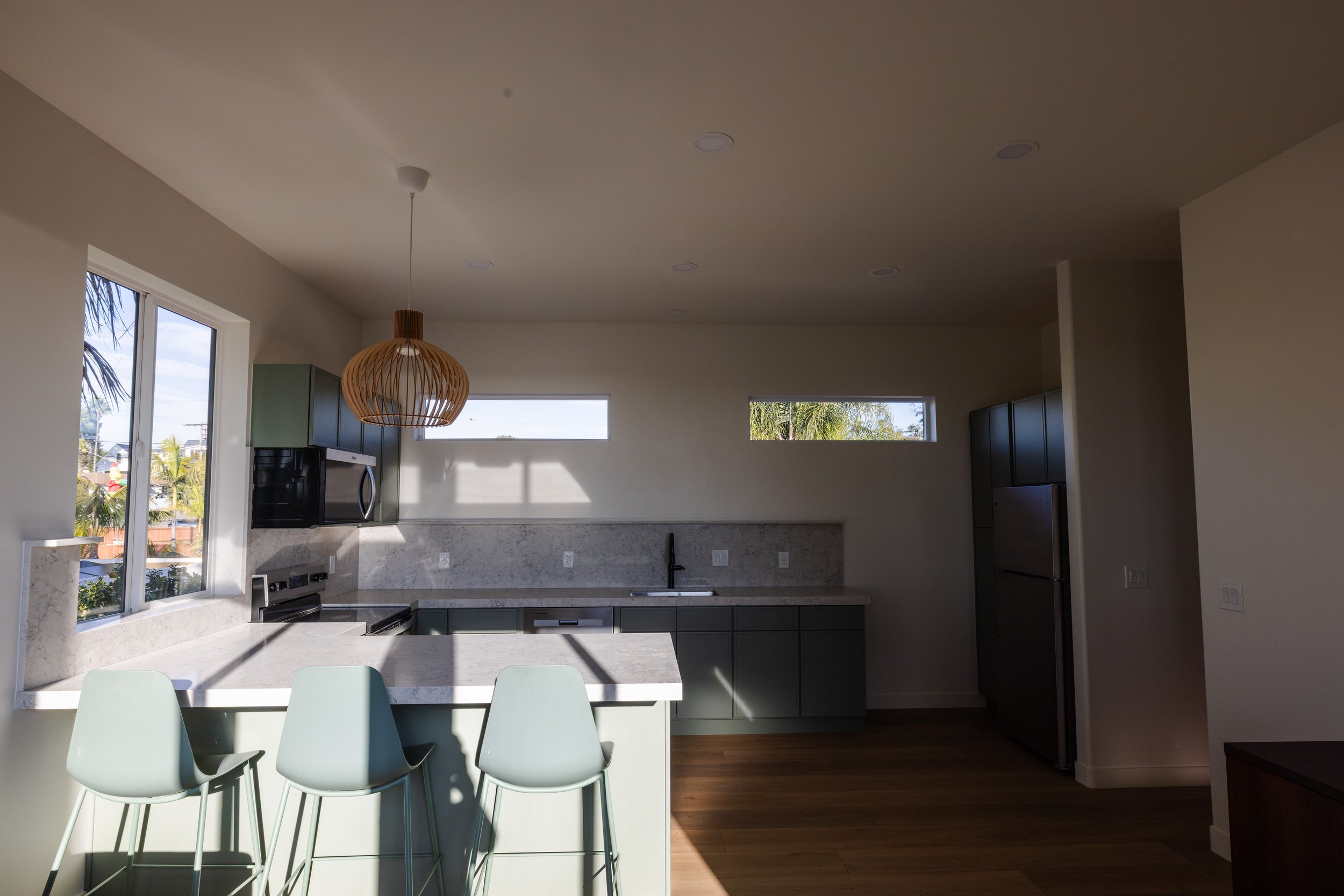 Interior shot of second story of new ADU in Carlsbad, California designed by Geis Architecture. Clean, fresh, calming kitchen design with Spanish style exterior. North County San Diego residential architecture