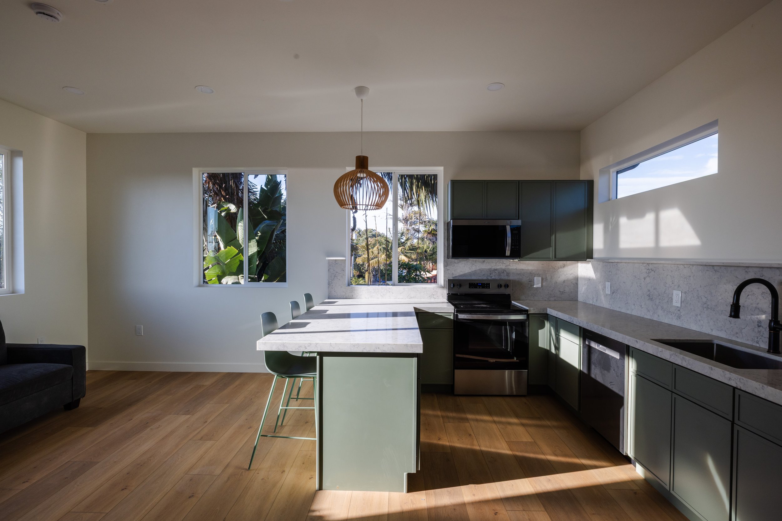 Image of kitchen remodel for ADU in Carlsbad, North County San Diego,California. Bright, clean, tropical trees show the elevated room designed by Geis Architecture
