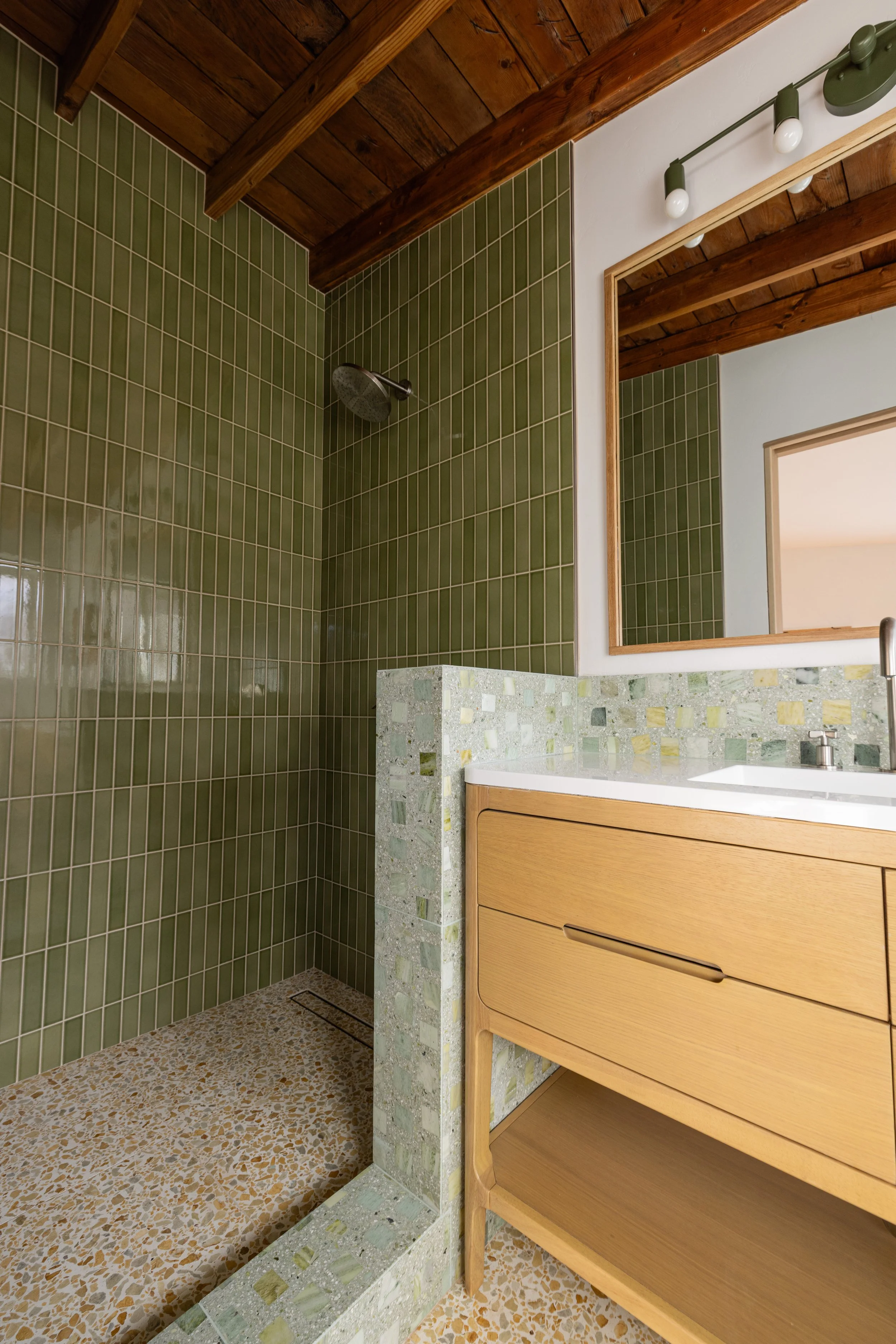 Shower with Kelp Forest Zia tile from floor to ceiling and Concrete Collaborative flooring, stem wall, and vanity backsplash. Mid century modern, luxury high end bathroom design