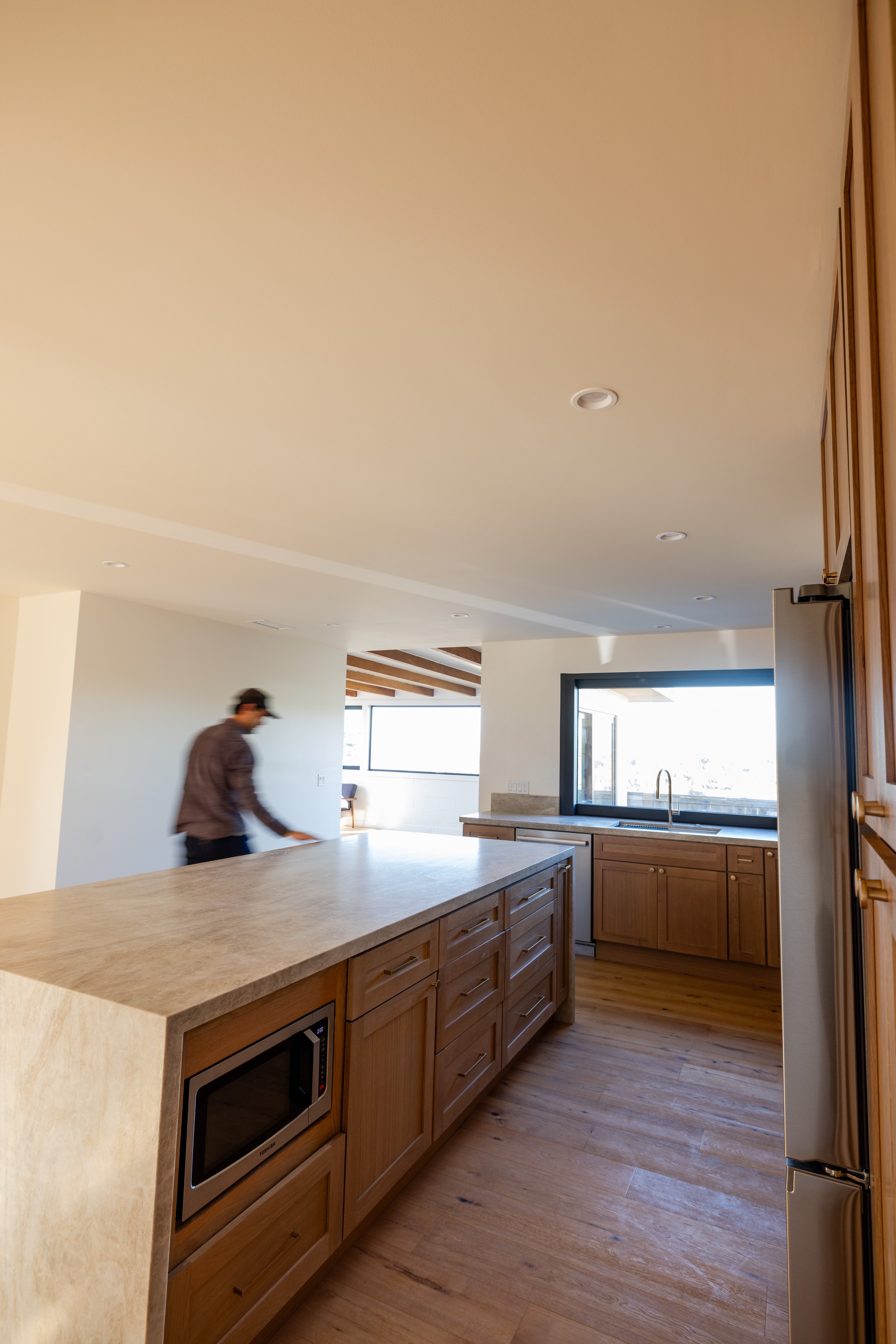 Man walking through a newly remodeled kitchen by Geis Architecture
