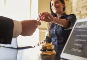 A woman is giving a credit card to a cashier at a counter in a fast food restaurant.