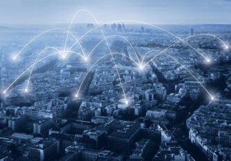 A city skyline with digital connection lines overlaid, symbolizing connectivity or communication networks.