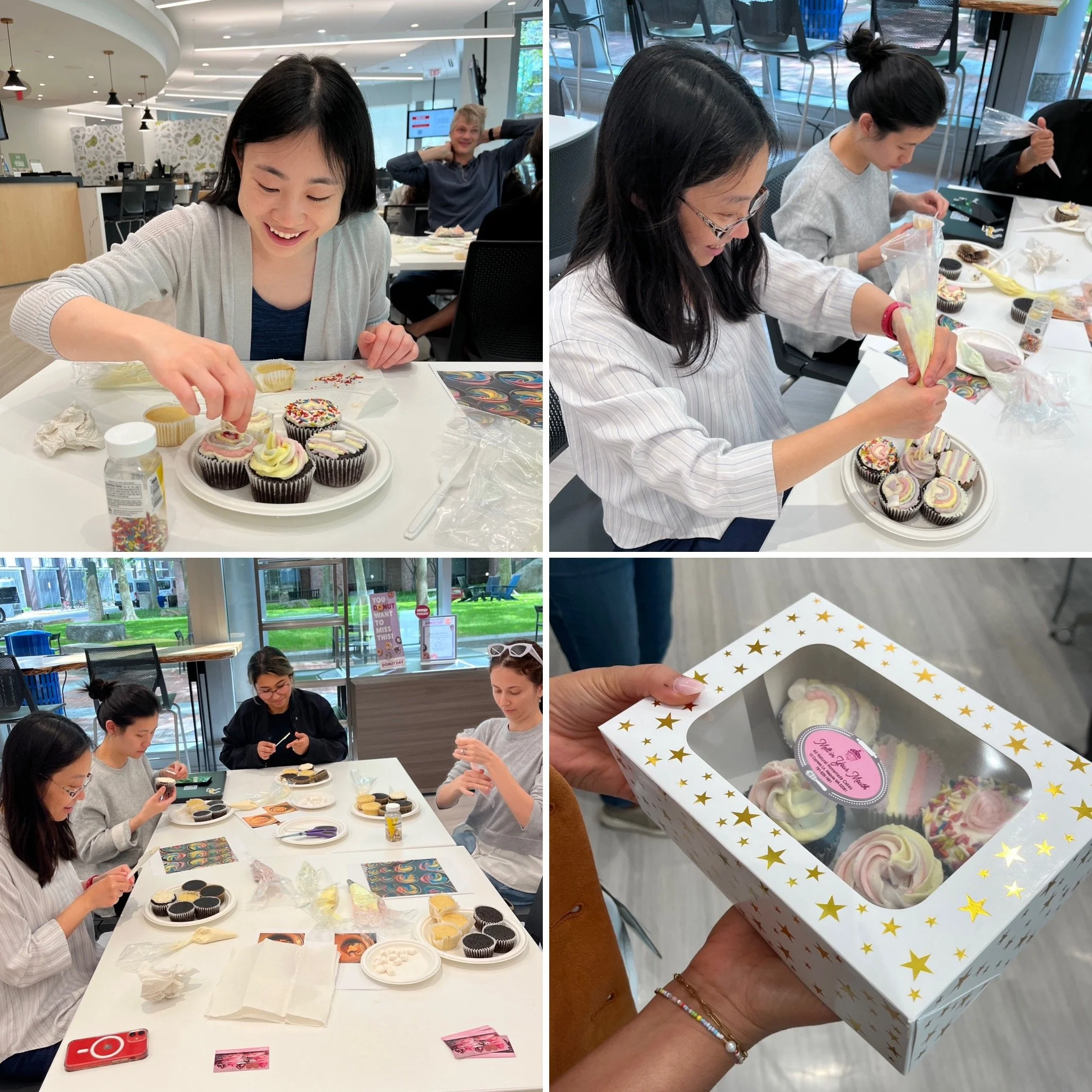 Array of decorated cupcakes on a table, some with pastel-colored frosting, sprinkles, and themed decorations. The table has tools, supplies, and packaging materials, indicating a cupcake decorating activity or event.