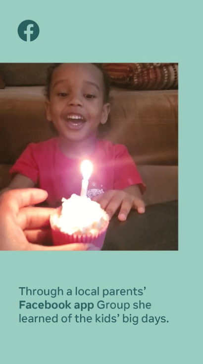 A young girl wearing a pink shirt celebrating a birthday with a lit cupcake in front of her.