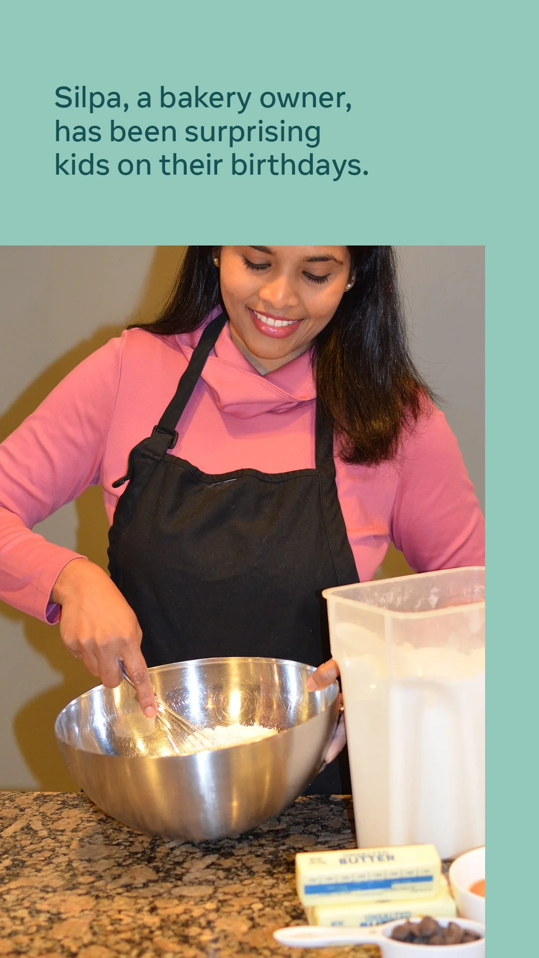 A woman with long dark hair wearing a pink hoodie and black apron, smiling while baking with a large stainless steel mixing bowl, butter, and ingredients on the kitchen counter. Text at the top mentions bakery owner Silpa surprising kids on their bir