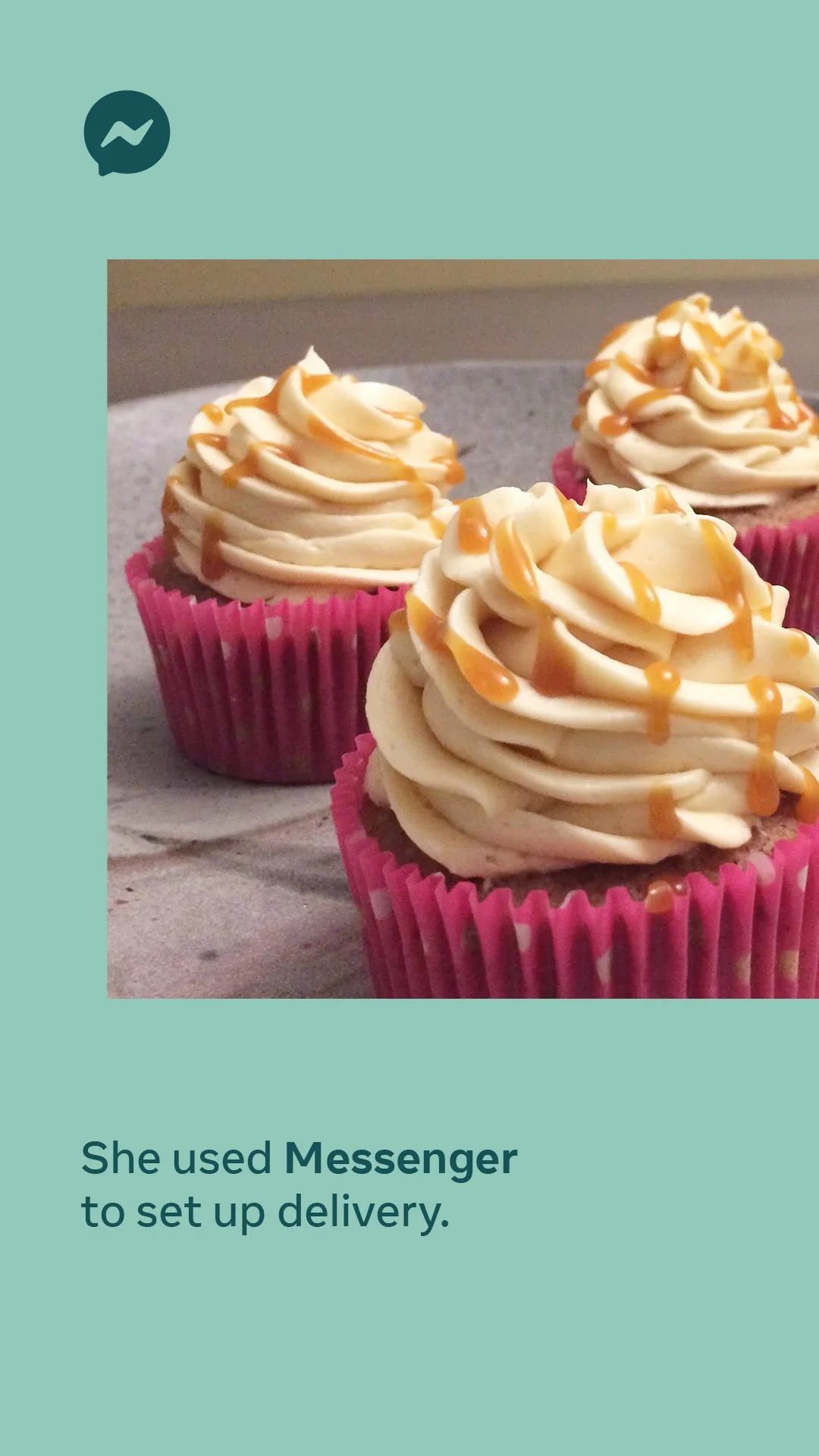 Three cupcakes with beige frosting and caramel drizzle in pink wrappers on a gray plate.