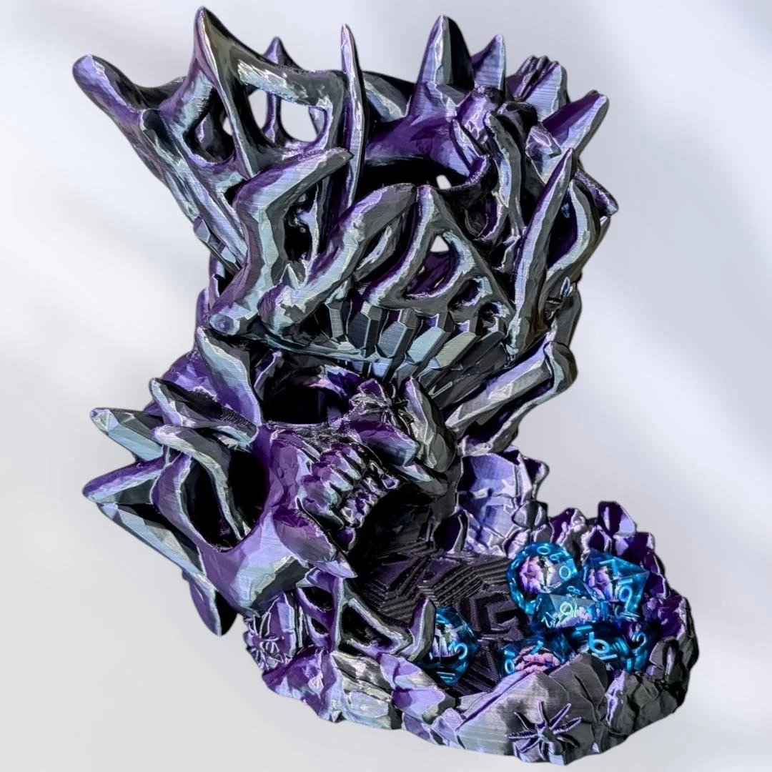 a 3d printed purple and black dice tower. features skulls and webs