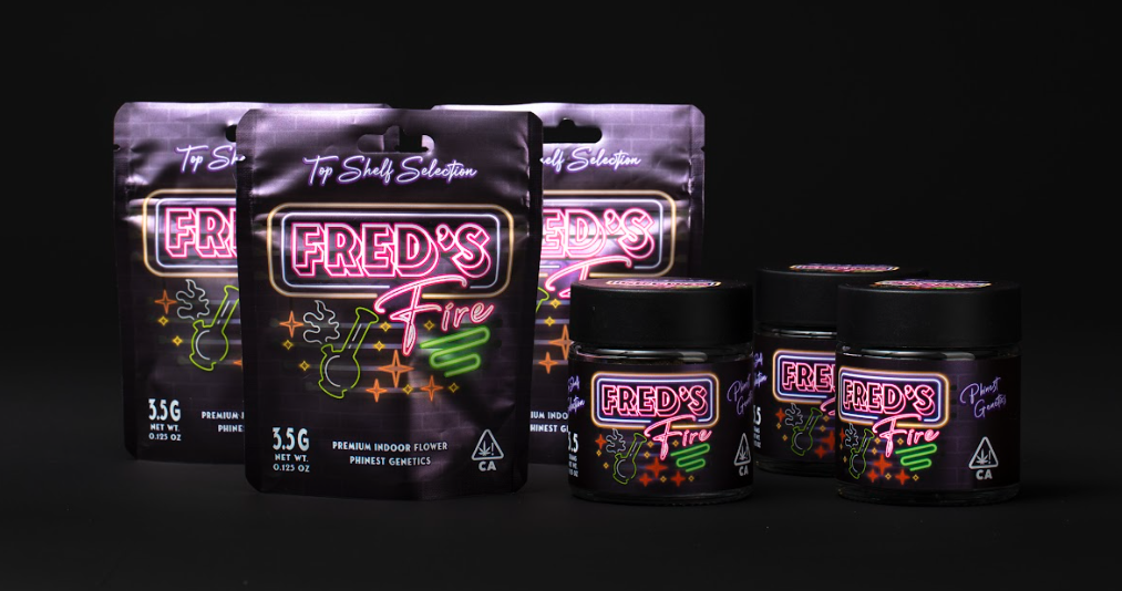 Package of Fred's Fire indoor flower CBD products with glowing neon-style labels, including pouches and jars against a black background.