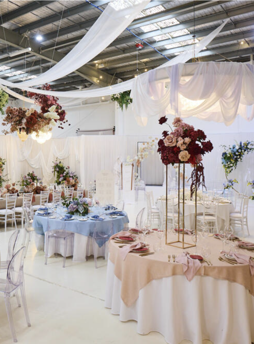 Elegant banquet hall decorated with flowers and drapery for a wedding or special event.