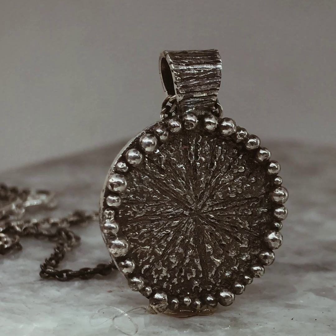 Dije de plata con diseño orgánico. 
