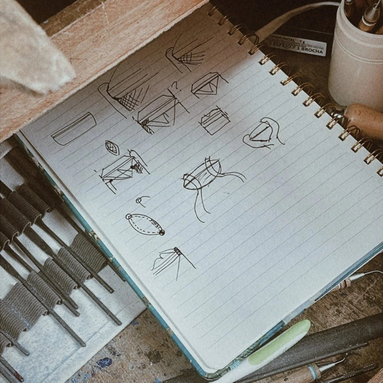 Cuaderno con dibujos de patrones y apuntes de joyería.