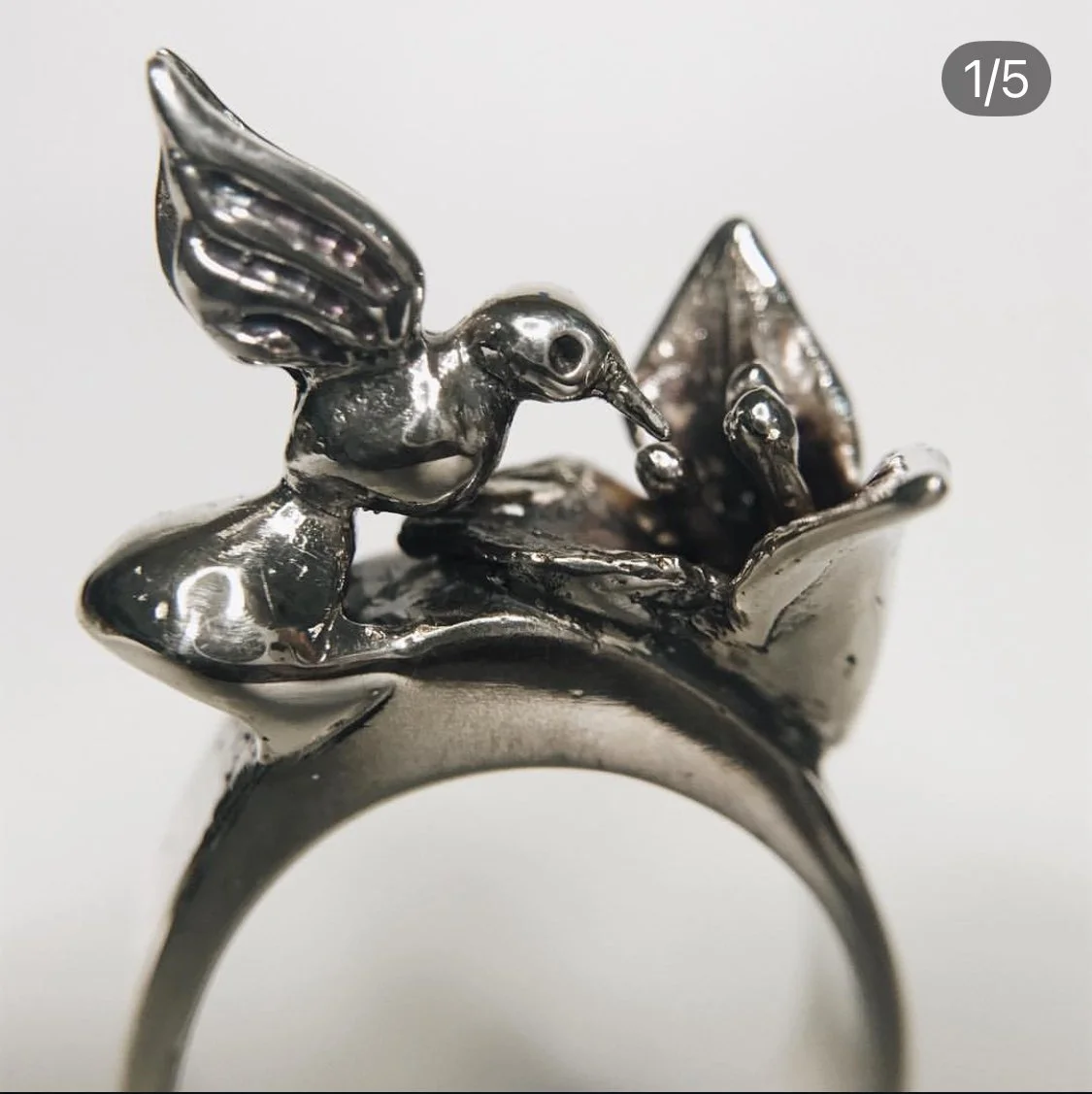 Anillo de plata con figura de colibrí en vuelo.
