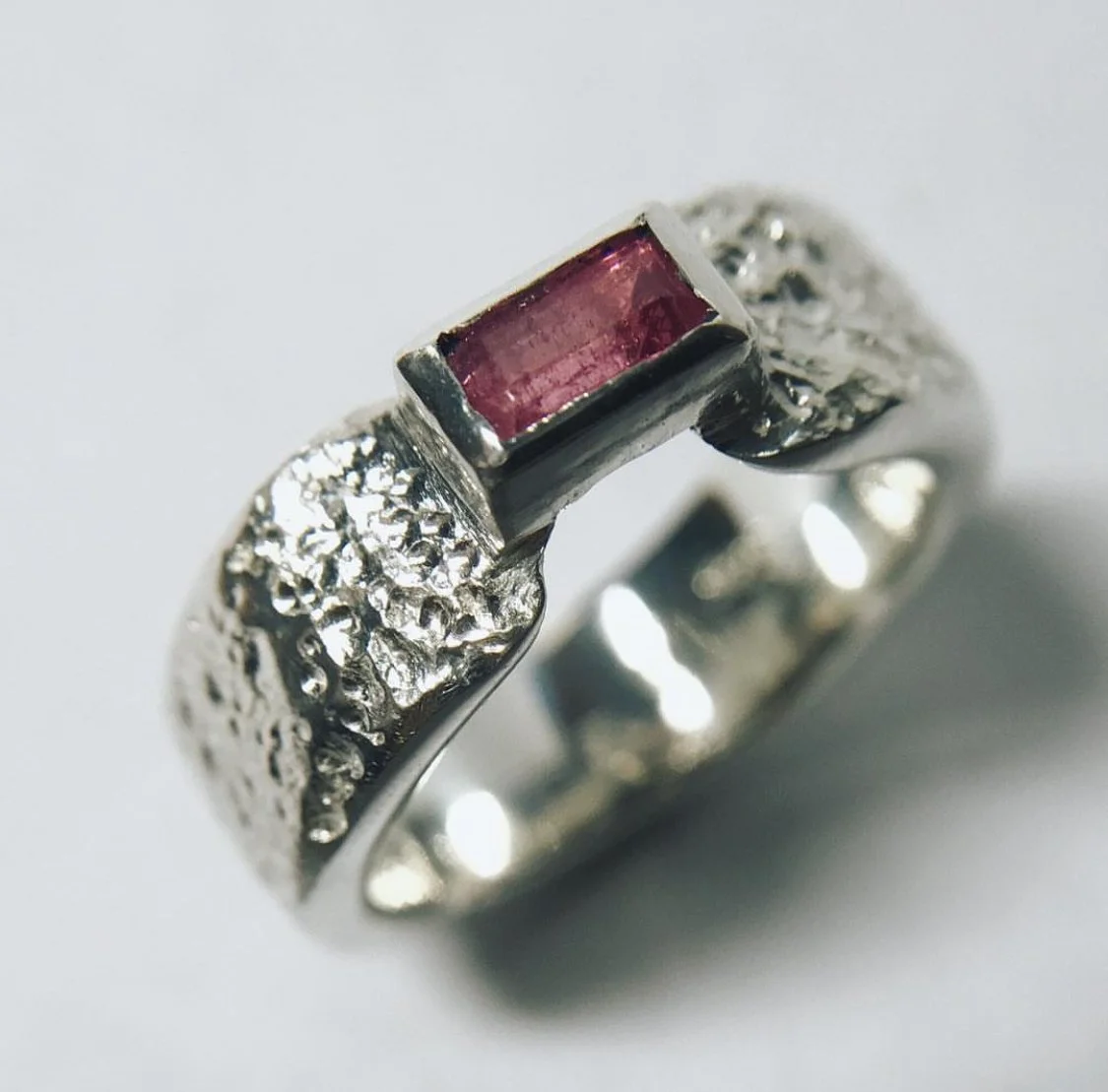 Anillo de plata con piedra de color rosa en el centro