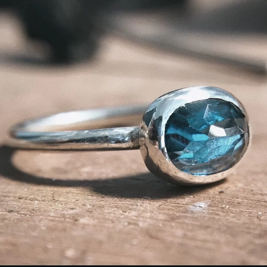 Anillo de plata con piedra azul montada a bisel. 