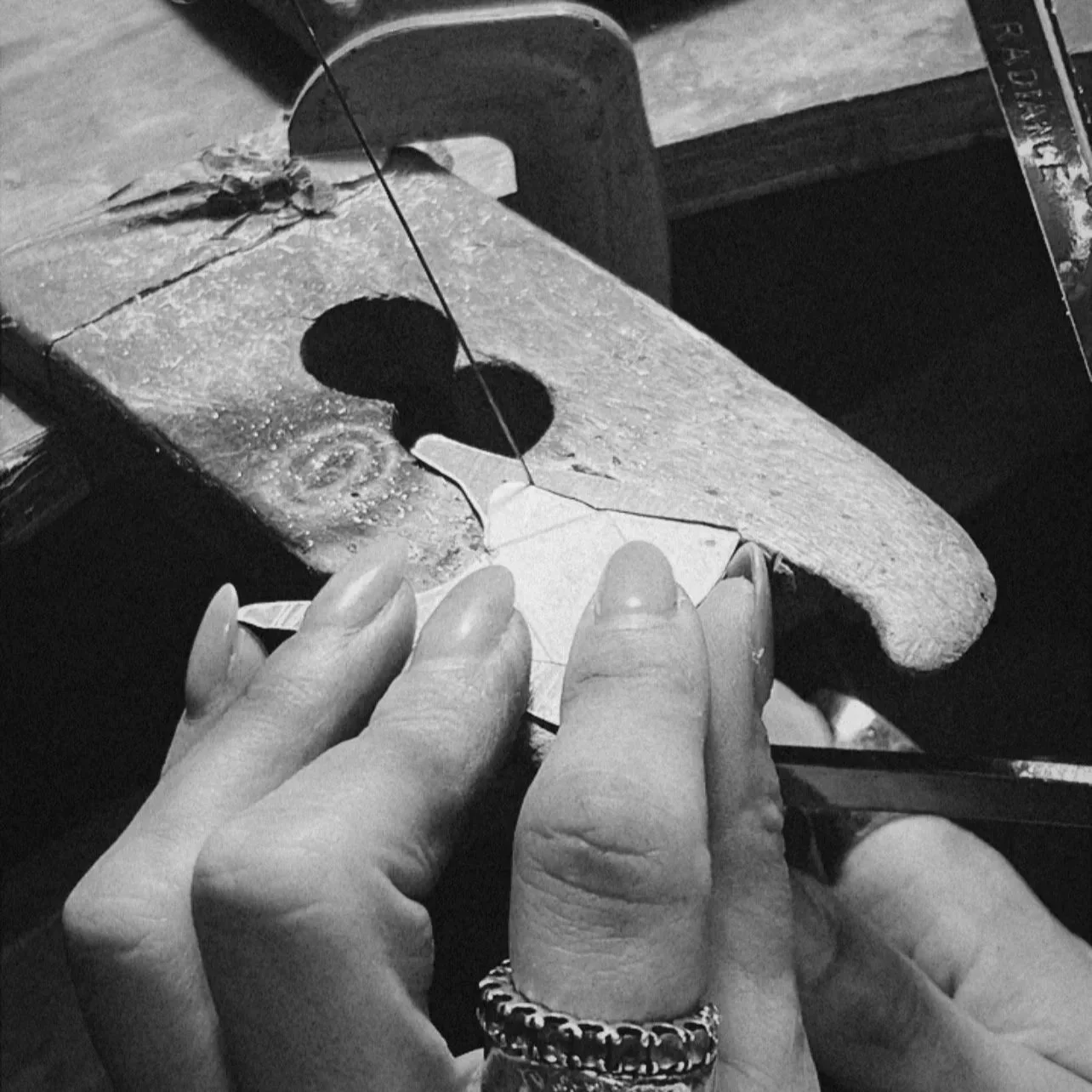 Manos creando una pieza de joyería en un taller