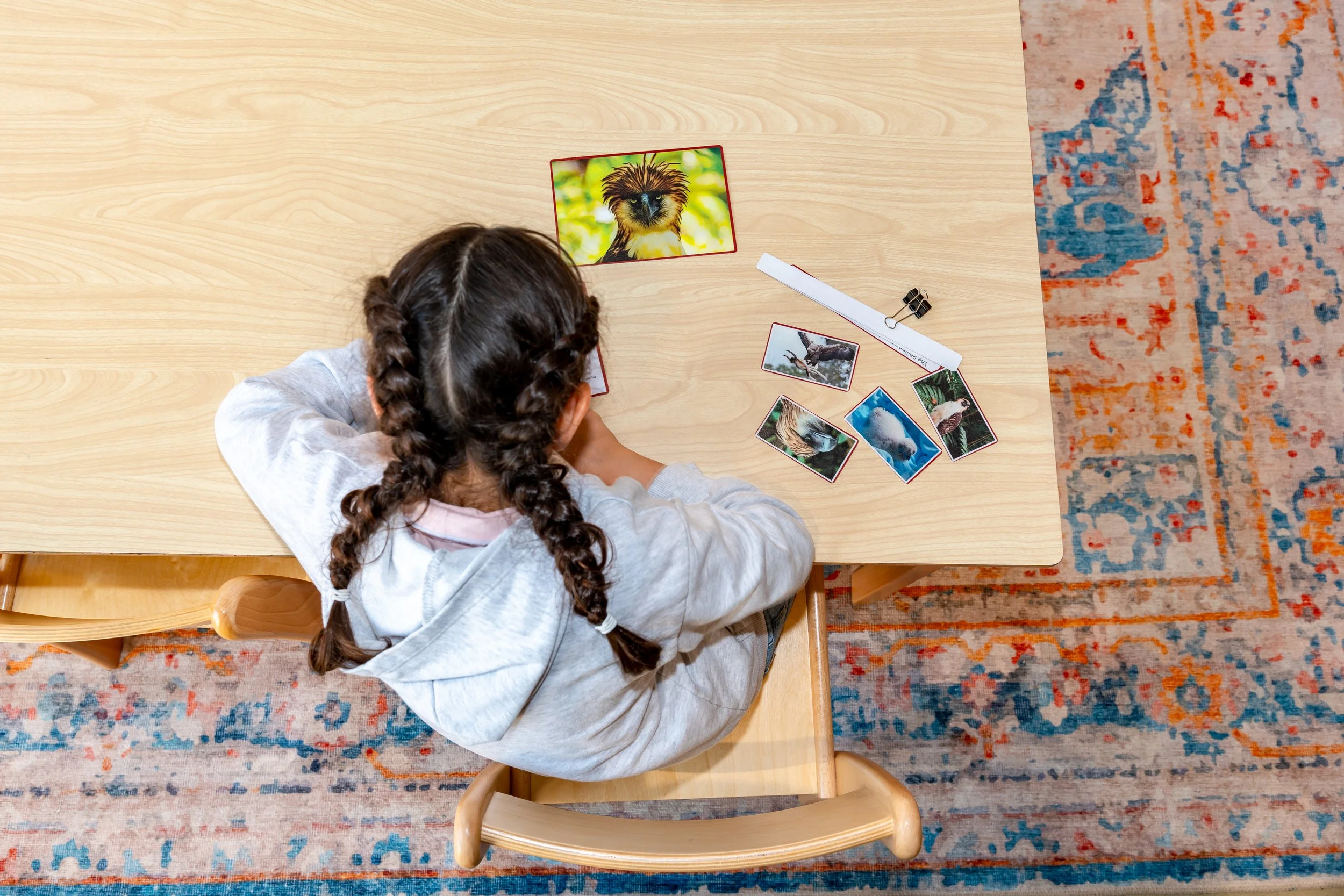 إكسيليفون ملون للأطفال مع مطرقتين في سلة منسوجة على رف خشبي.