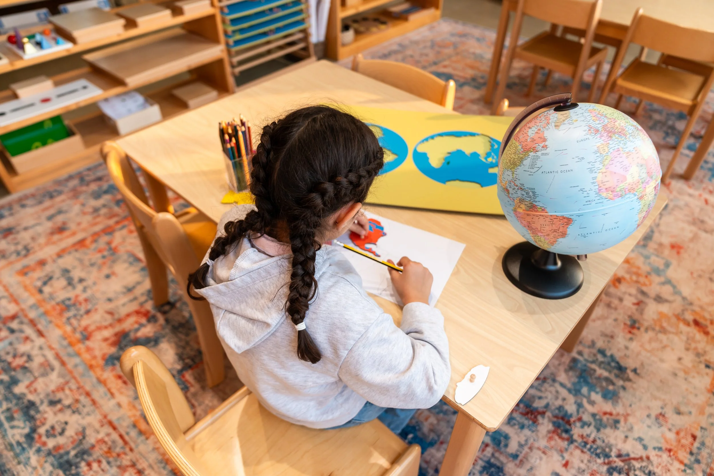 إكسيليفون ملون للأطفال مع مطرقتين في سلة منسوجة على رف خشبي.