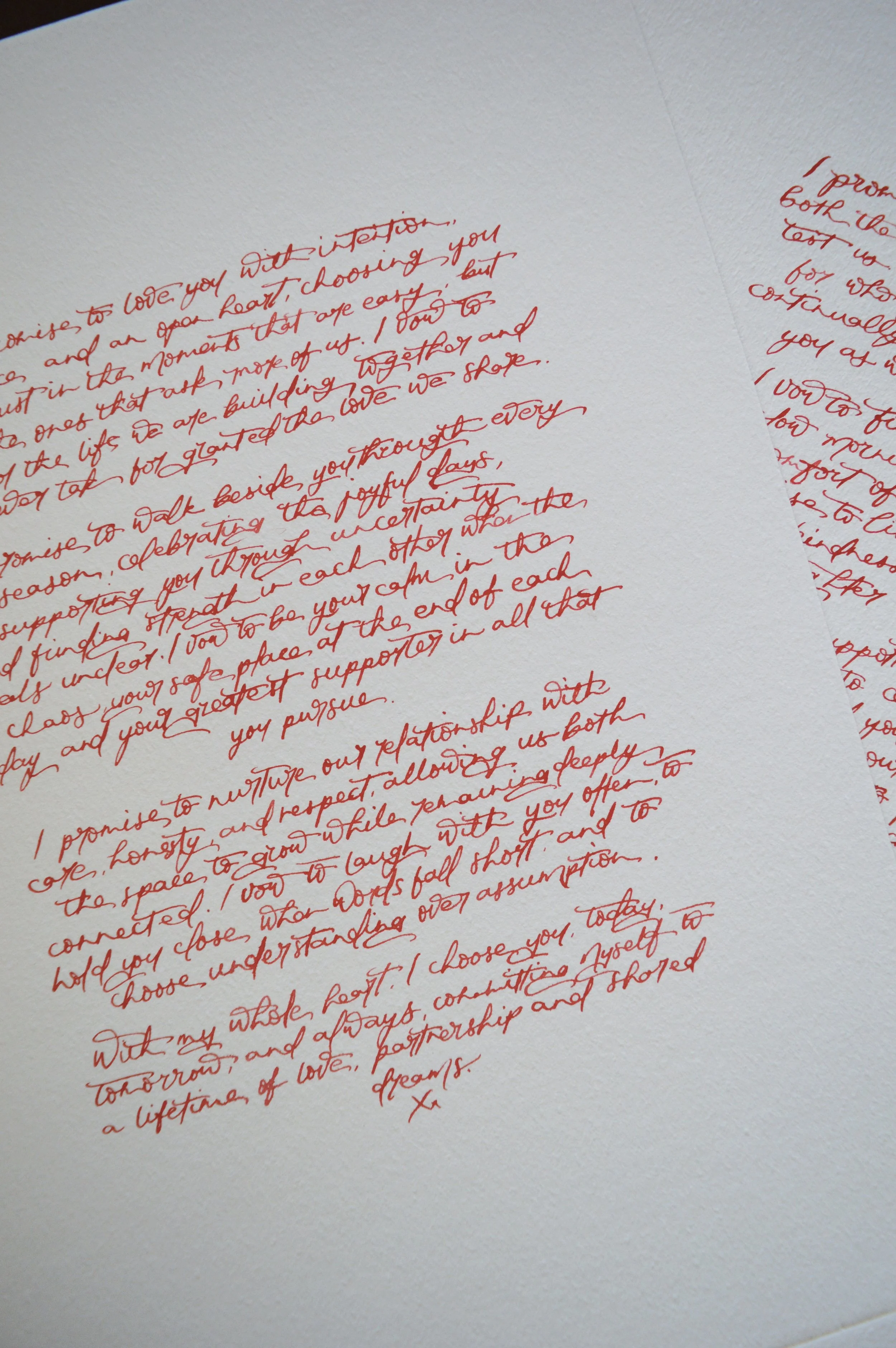 Handwritten wedding vows in red ink on premium white cardstock, styled as a modern calligraphy vow keepsake