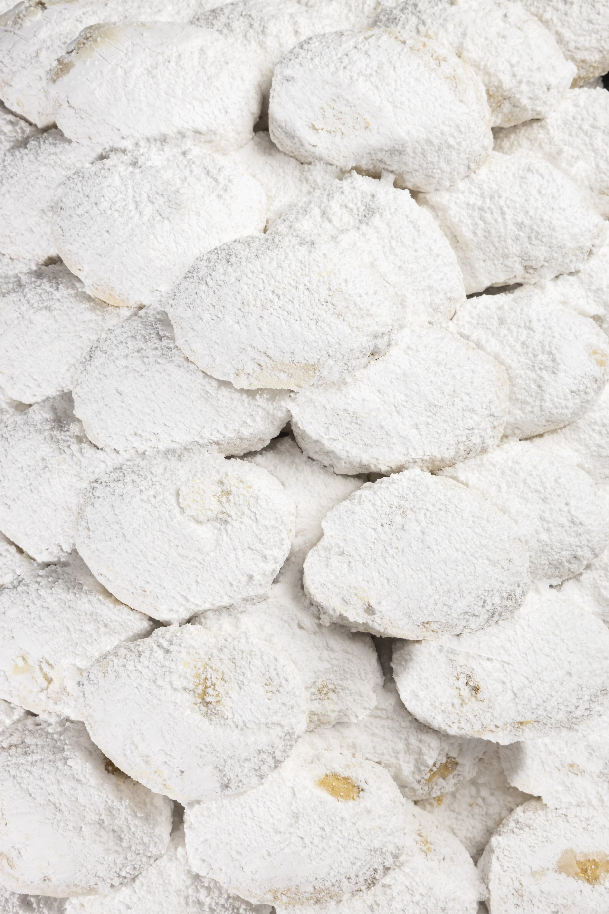 Several pieces of meringue cookies coated in powdered sugar.