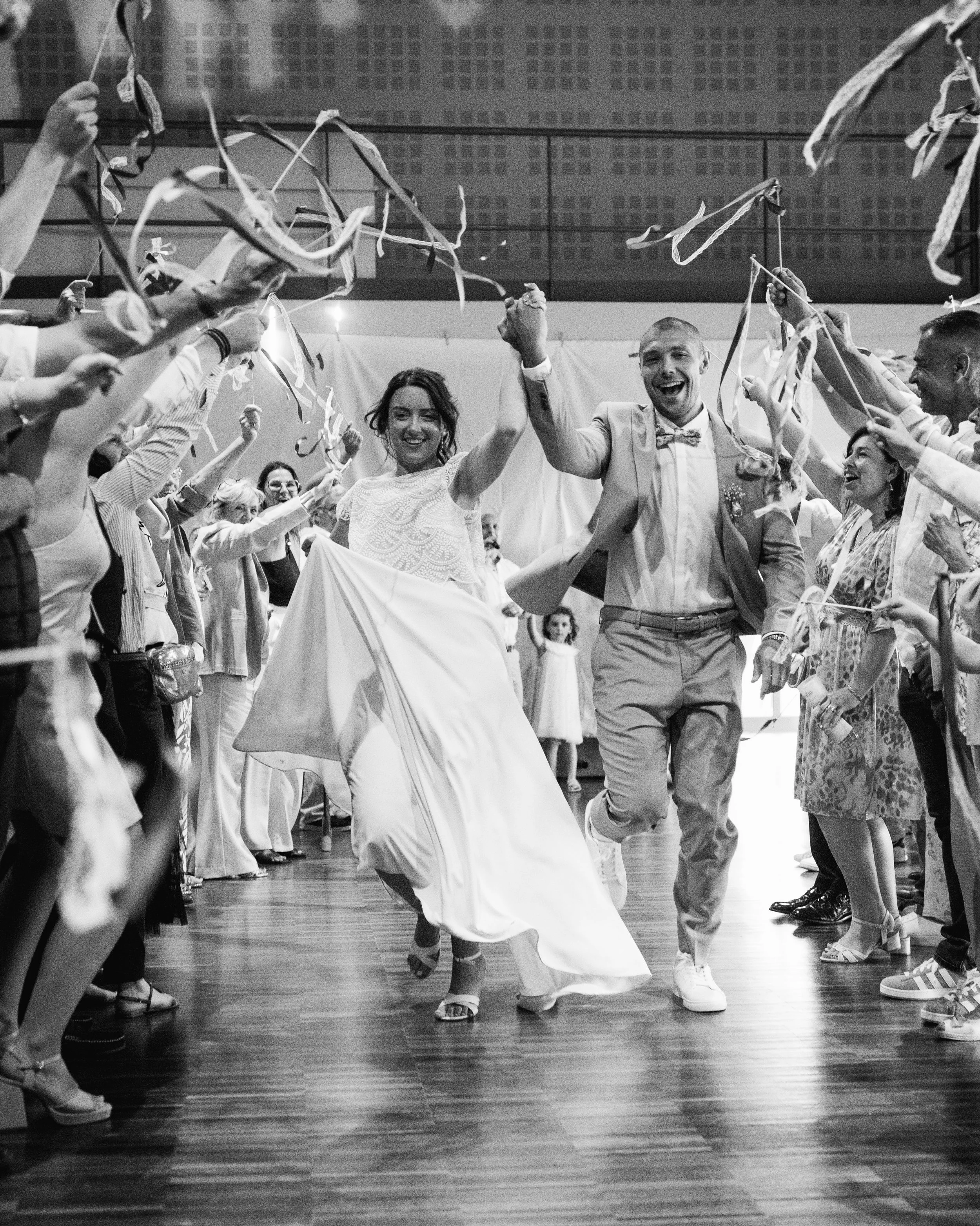 Des gens dansant lors d'une célébration avec des confettis et des banderoles, sabotage en blanc et noir.