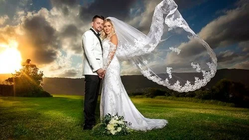Wedding portrait with a flowing veil at sunset