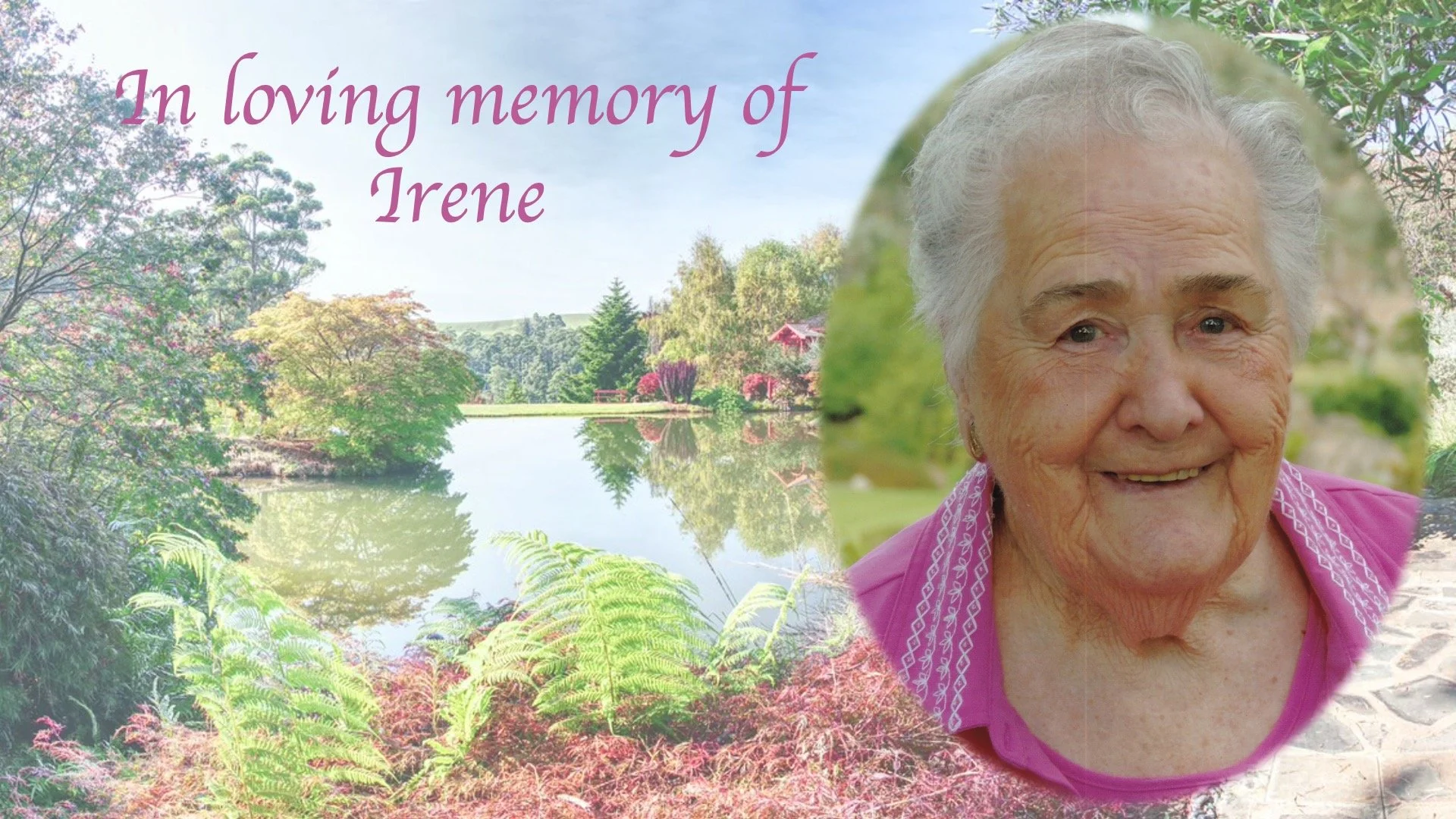 A memorial tribute with a peaceful lake, trees, and pink flowers in the background, and a smiling elderly woman with white hair in a pink top on the right side. The text reads, "In loving memory of Irene."