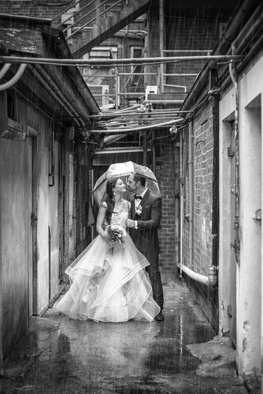 Wedding couple photographed under an umbrella