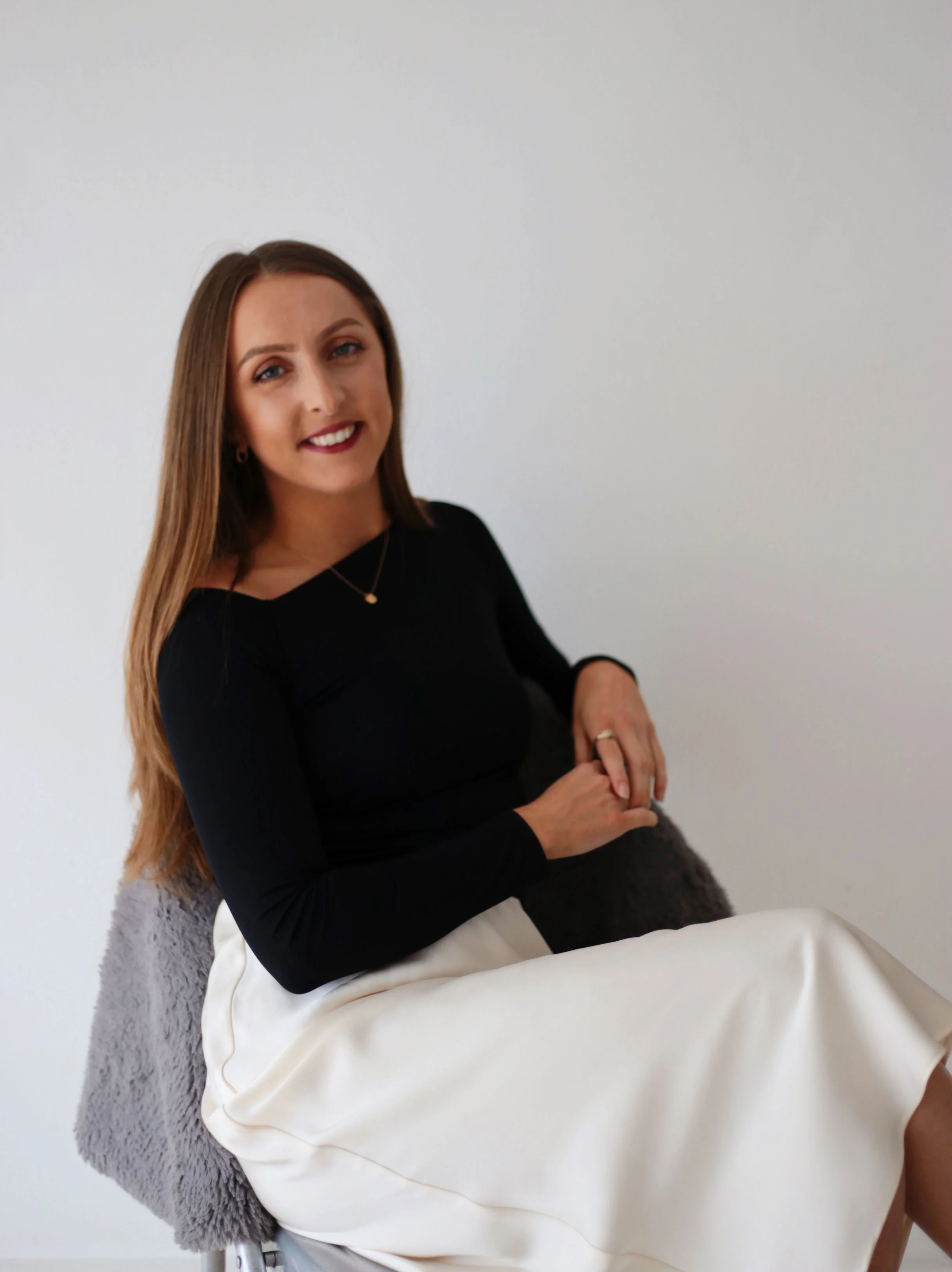 Emily smiling softly in natural light, embodying calm and approachability