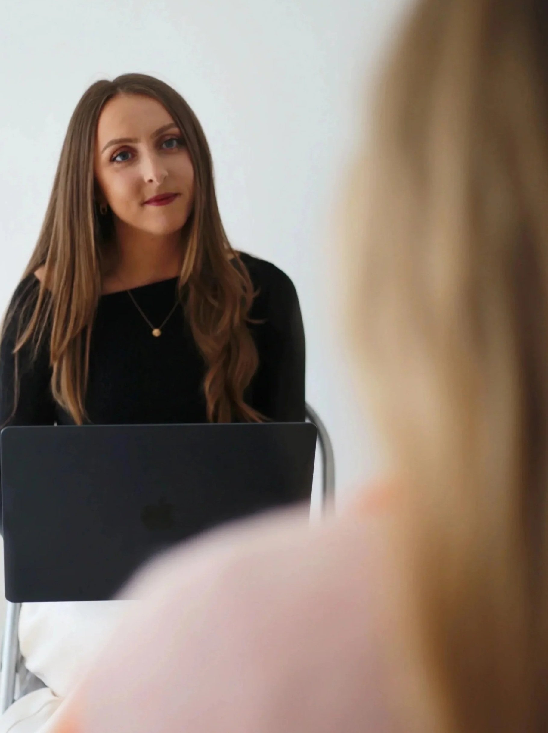 Emily, trauma-informed yoga teacher and emotional wellbeing coach, smiling in calm natural light