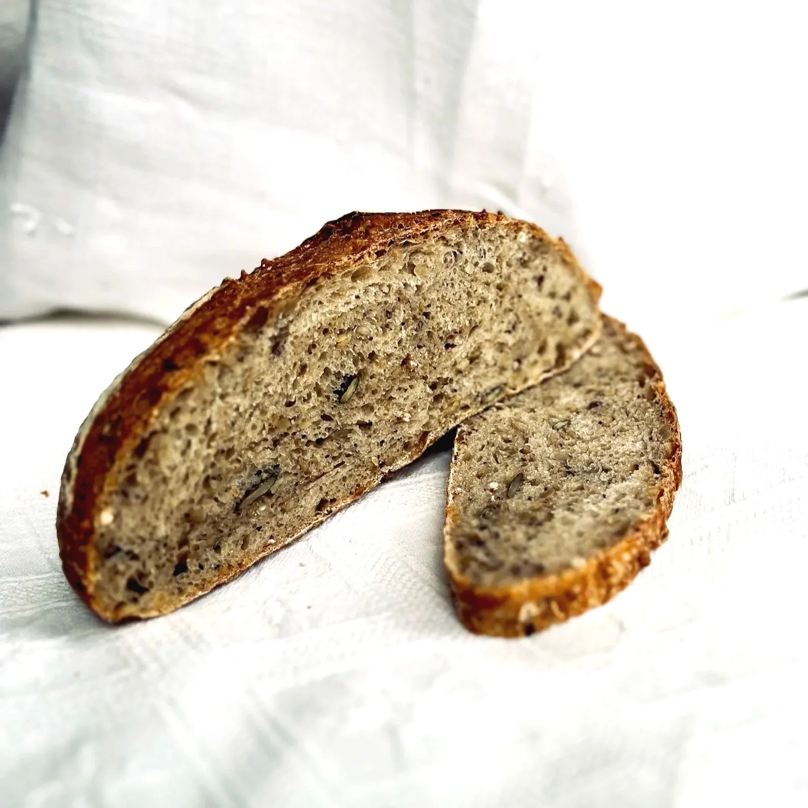 Handwerklich gebackenes Seeded Sourdough aus Weizenmehl und eine aromatische Mischung aus Sonnenblumen- und Kürbiskernen, Buchweizen, Leinsamen, Sesam, Amaranth und Blaumohn.