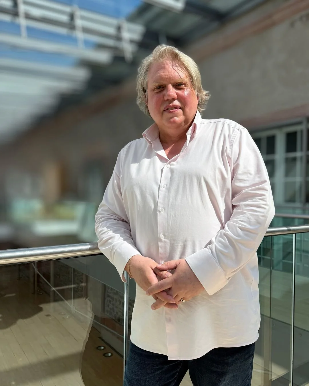 Ein Mann mit blondem Haar, Anzug und Krawatte, lächelnd bei einer Veranstaltung.