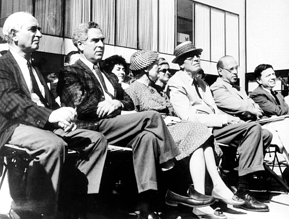Group of people sitting in a row in a conference room attending an event.