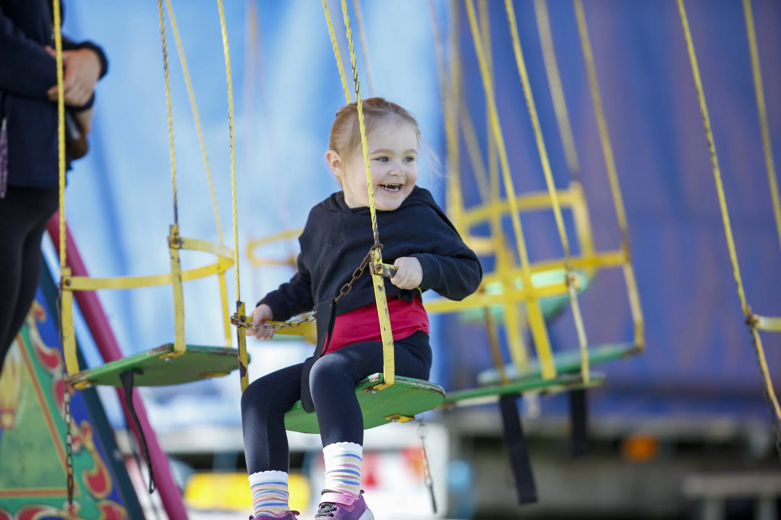 Little girl on fairground ride smiling.jpg