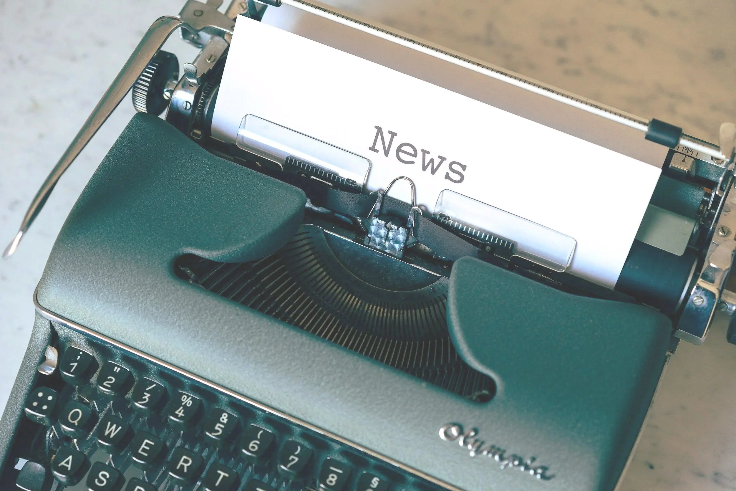 A vintage typewriter with a paper inserted reading 'News'