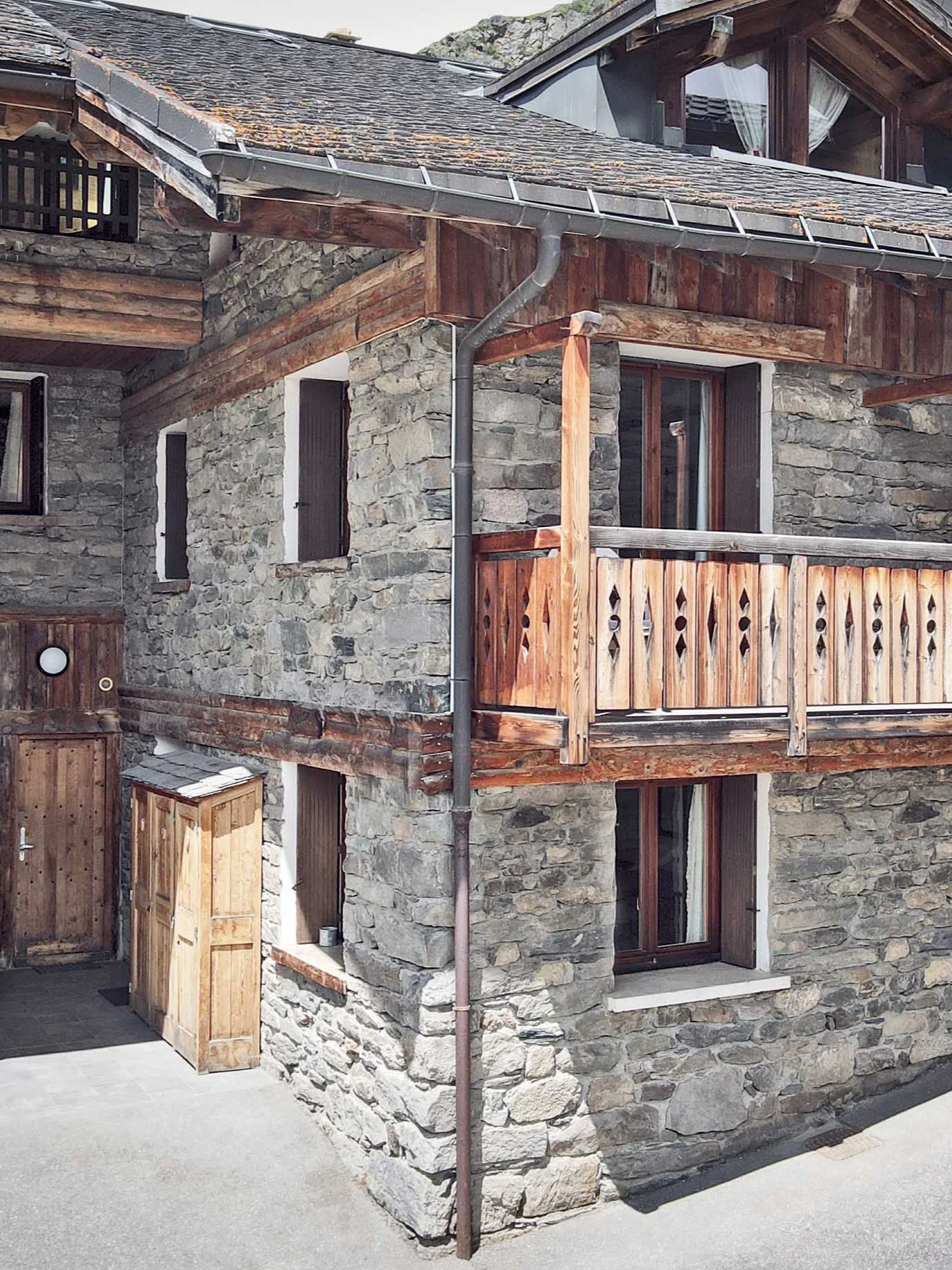 Façade d’un chalet savoyard en pierre et bois proposé à la vente par HOME SUMMIT dans la vallée des Belleville, à proximité des Menuires.
