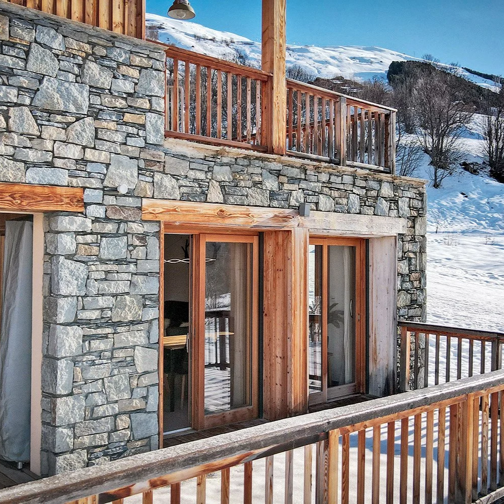 Appartement à vendre aux Les Menuires, situé au pied des pistes, avec terrasse offrant une vue dégagée sur les montagnes environnantes, idéal résidence secondaire ou investissement en montagne.