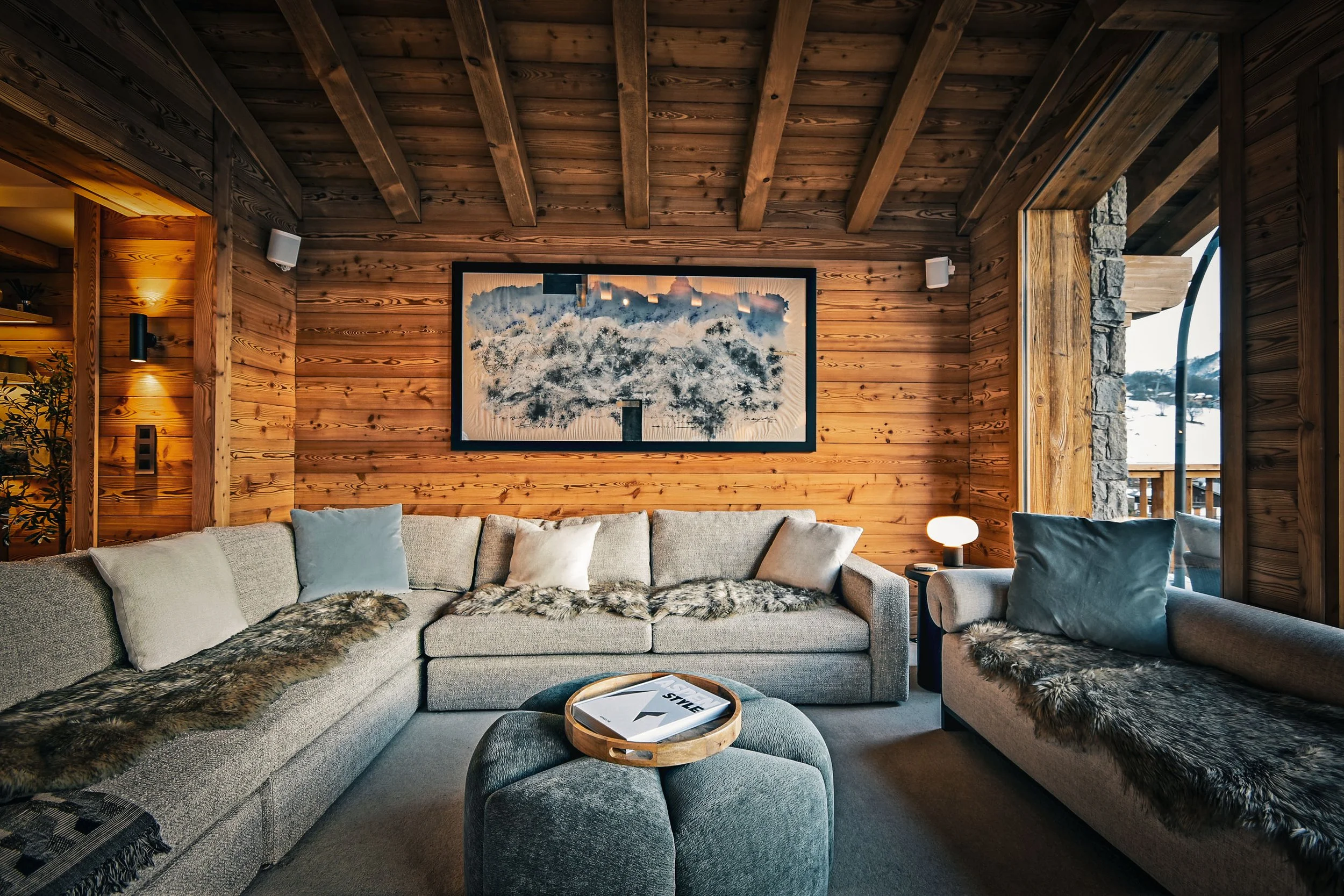 Salon de chalet à Saint-Martin-de-Belleville, décoration feutrée et chaleureuse, ambiance alpine haut de gamme. Idéal pour un investissement immobilier rentable au cœur du prestigieux domaine des 3 Vallées.