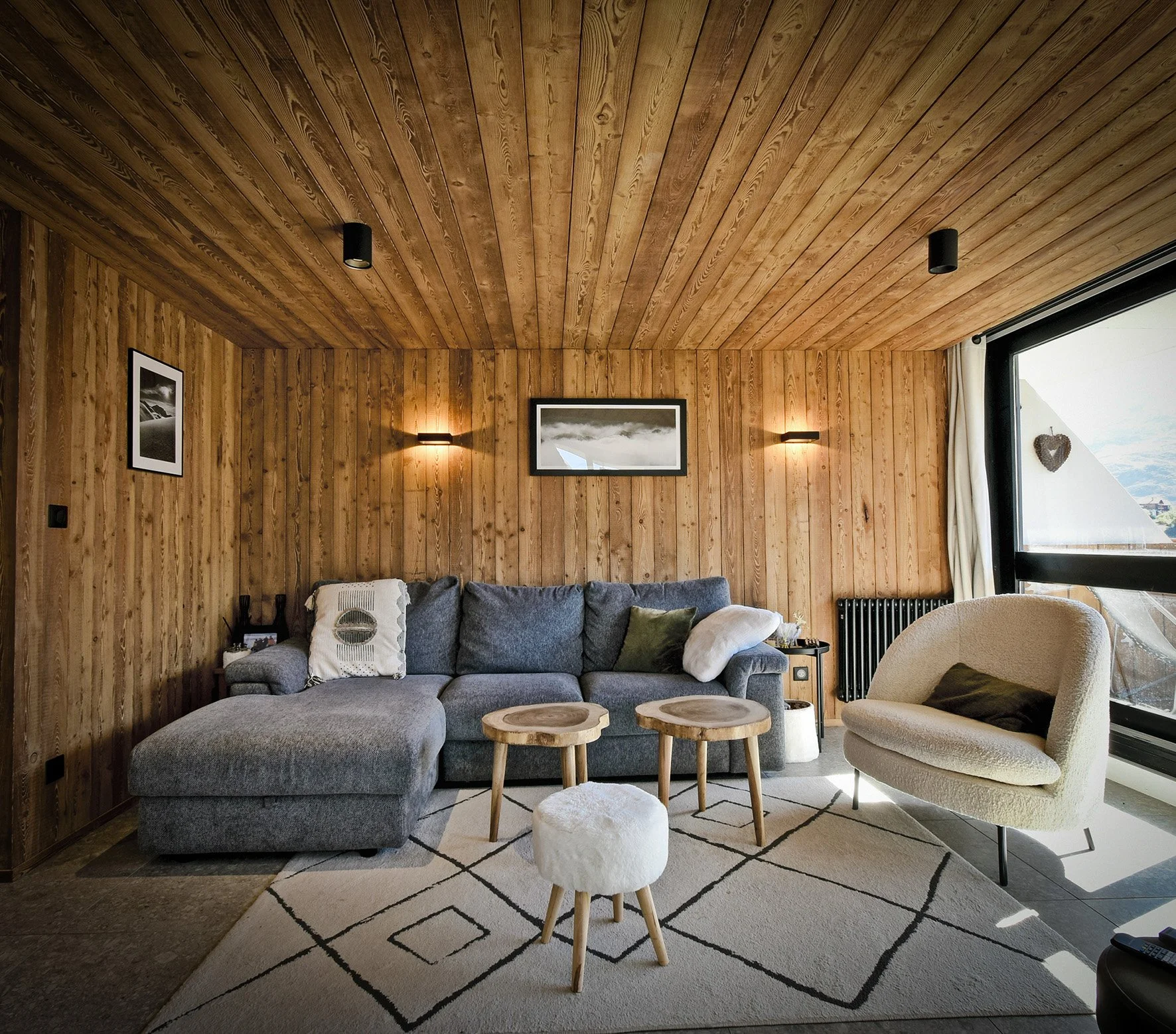 Salon et séjour d’un appartement à vendre sur les hauteurs des Menuires, présenté par l'agence immobilière HOME SUMMIT. Espace lumineux avec vue dégagée sur les montagnes, idéal pour un investissement immobilier en station alpine.