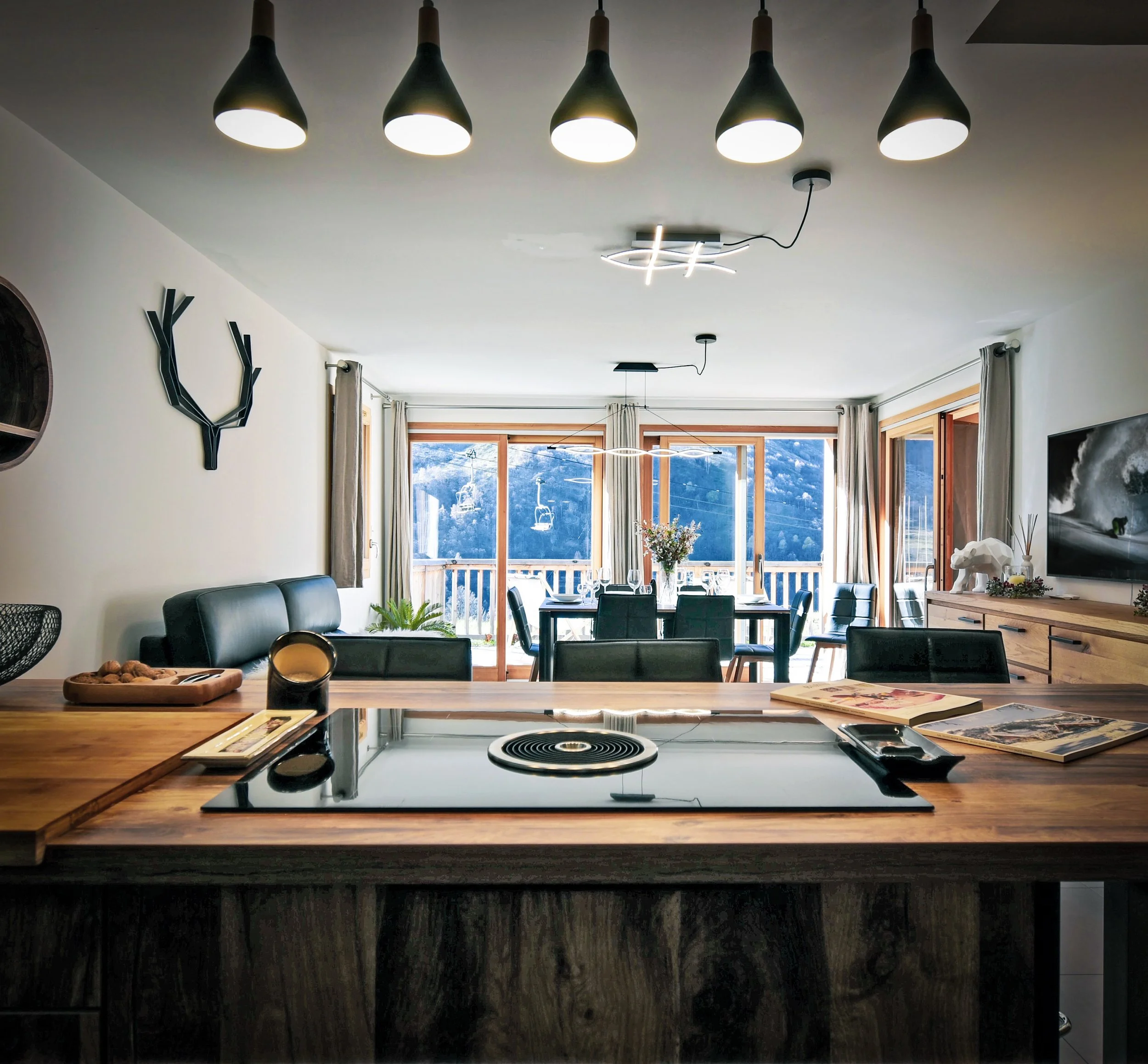 Cuisine américaine ouverte sur un salon cosy et un séjour lumineux, dans un appartement au pied des pistes aux Menuires. Bien à l’achat, idéal pour un projet familial ou un investissement en gestion locative en station de ski.