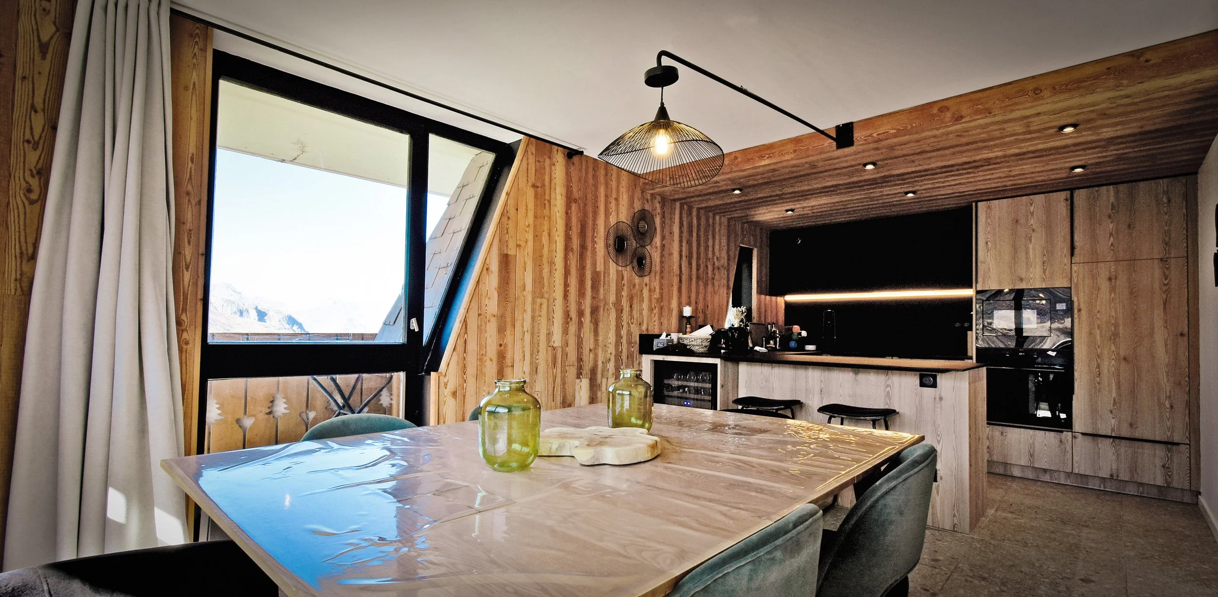 Salle à manger conviviale et raffinée pour 8 personnes, avec belle table et décoration chaleureuse, dans un appartement à vendre sur Les Menuires, parfait pour investissement immobilier en station de ski.