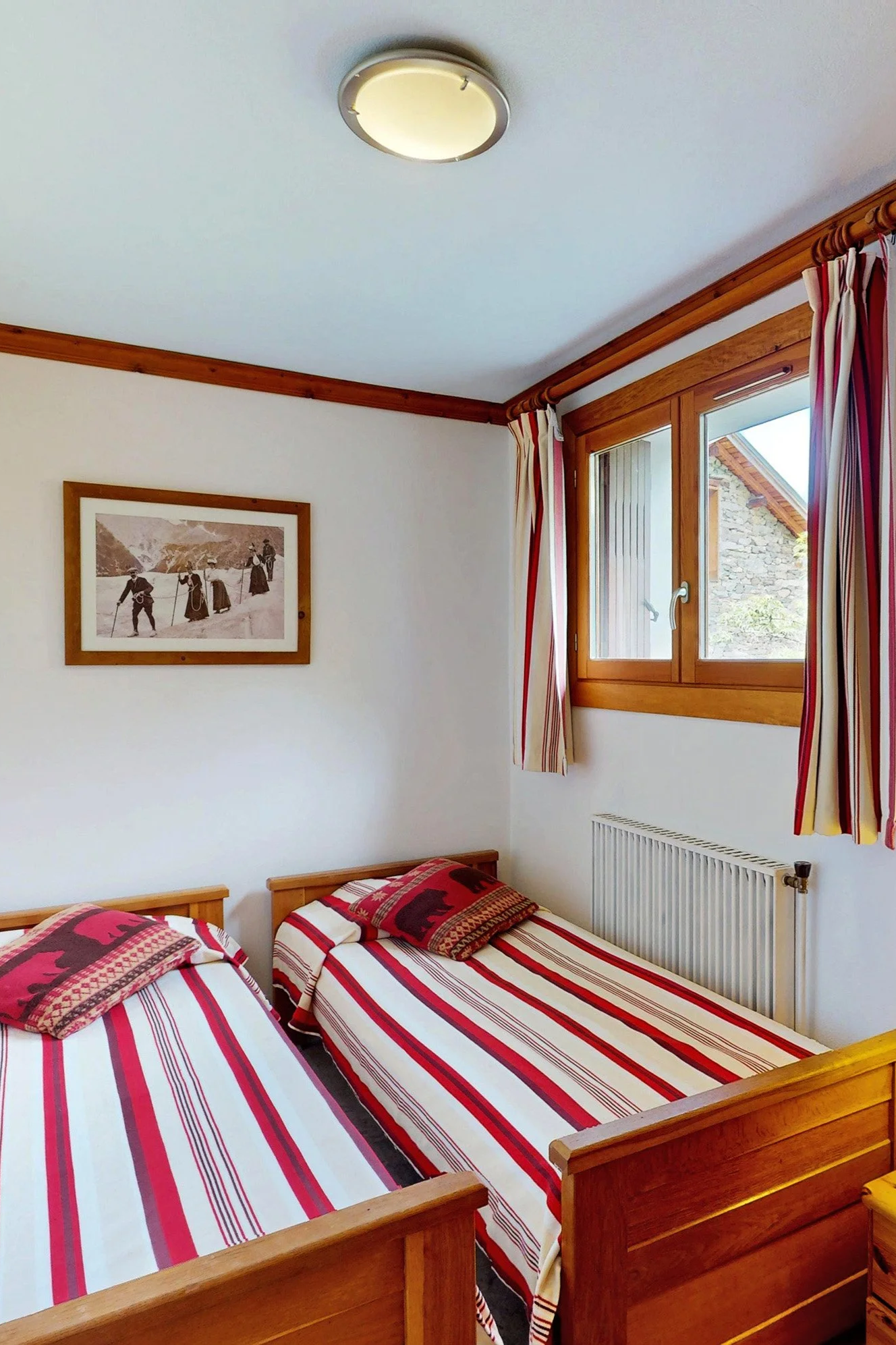 Chambre avec lits simples au sein d’un chalet proposé à la vente par HOME SUMMIT, offrant une vue dégagée sur les montagnes et une ambiance chaleureuse de montagne.