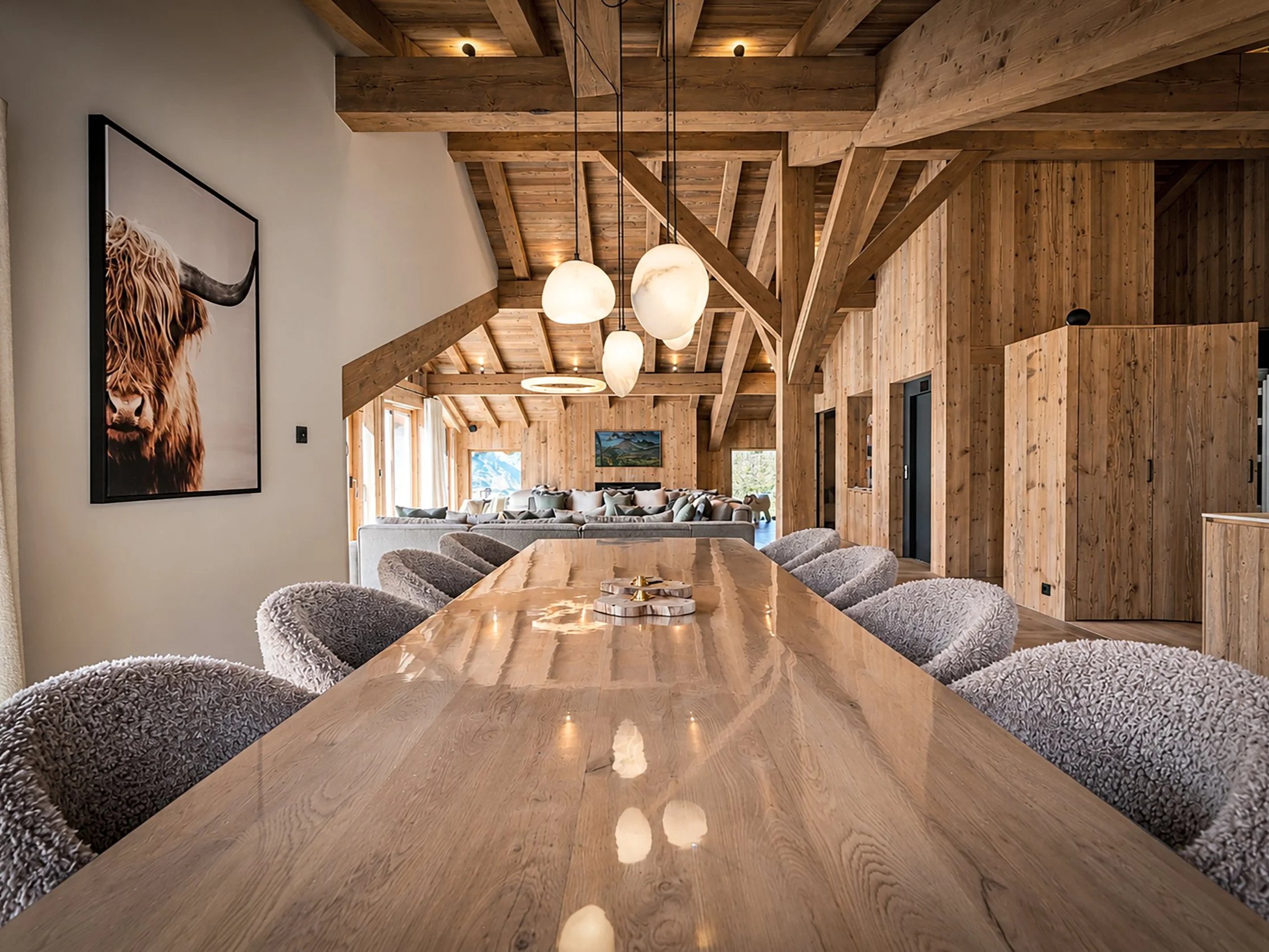 Salle à manger d’un chalet de prestige à Saint-Martin-de-Belleville, grande table en bois, charpente apparente et décoration alpine contemporaine.