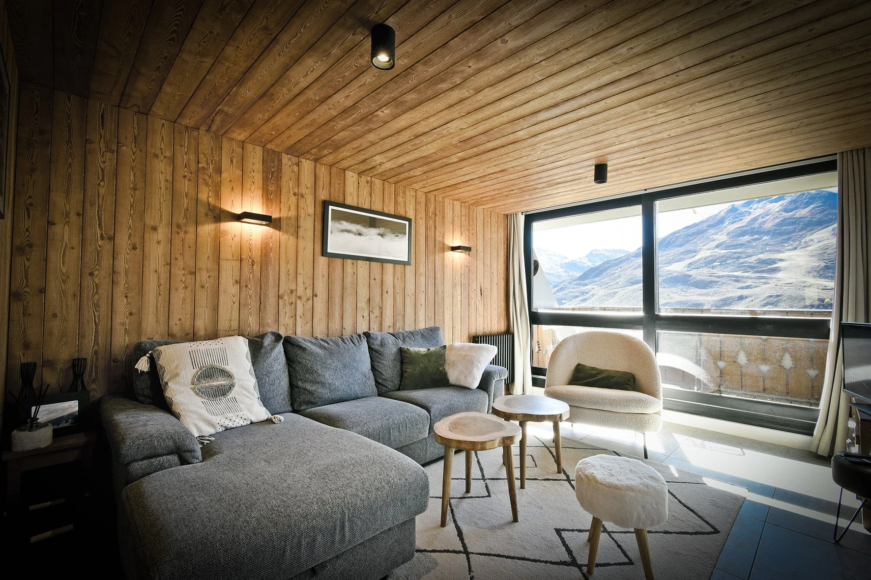 Salon entièrement rénové avec du vieux bois dans un appartement à vendre aux Menuires, alliant charme traditionnel et confort moderne, idéal pour un investissement immobilier en station de ski.