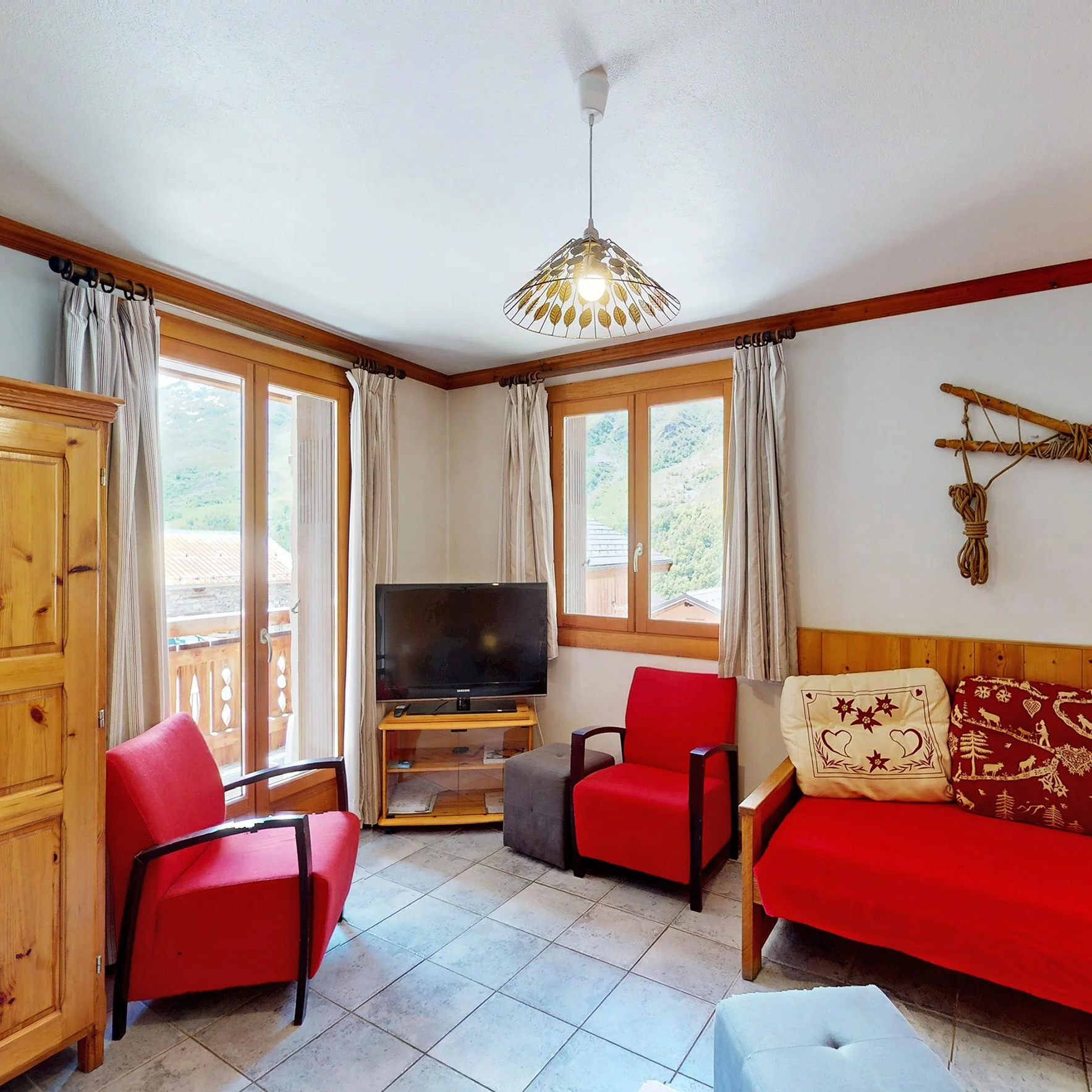 Chalet de montagne proposé à la vente par HOME SUMMIT, avec salon lumineux, accès extérieur et vue sur les paysages alpins environnants.