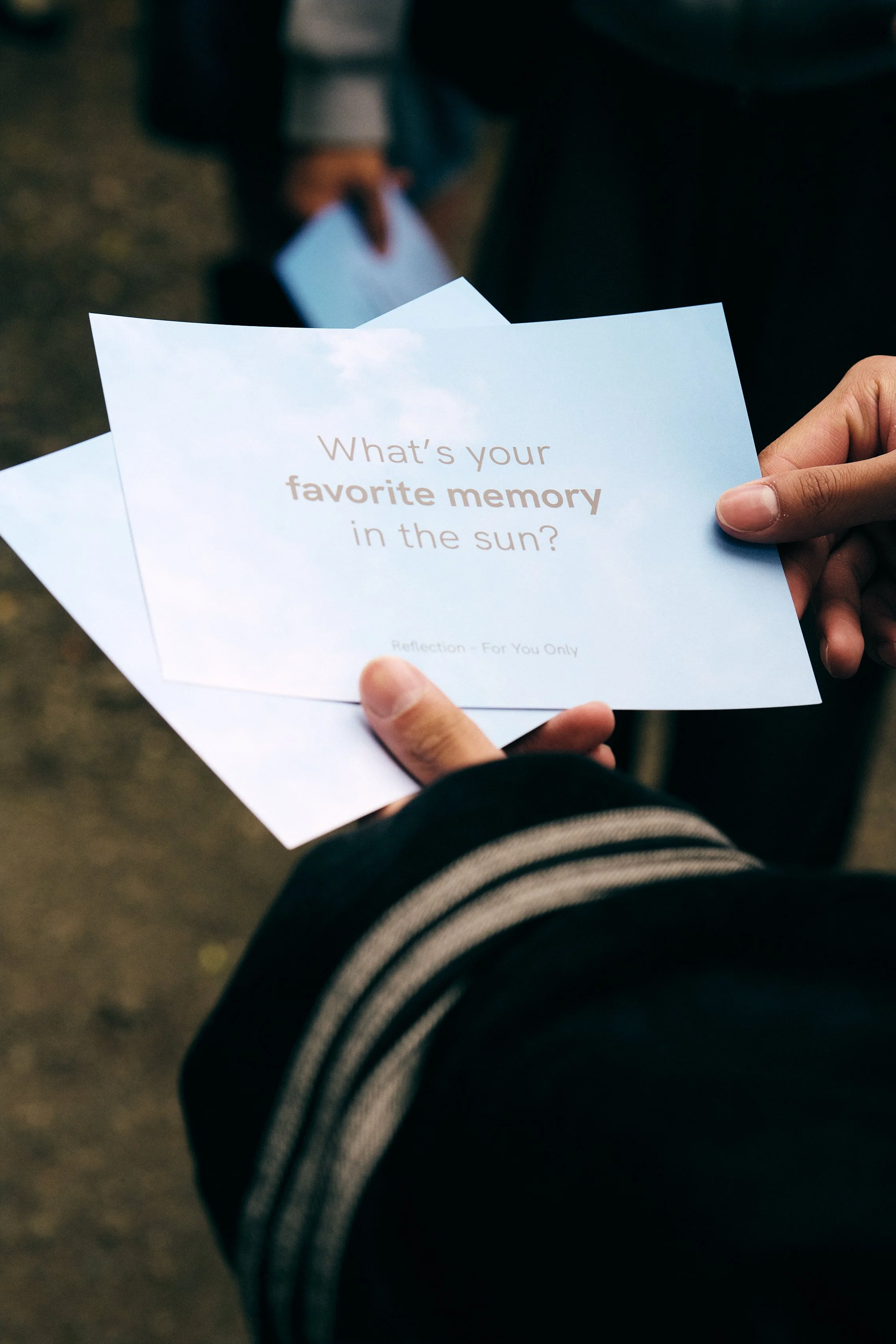 Person holding a card with the question, "What’s your favorite memory in the sun?"